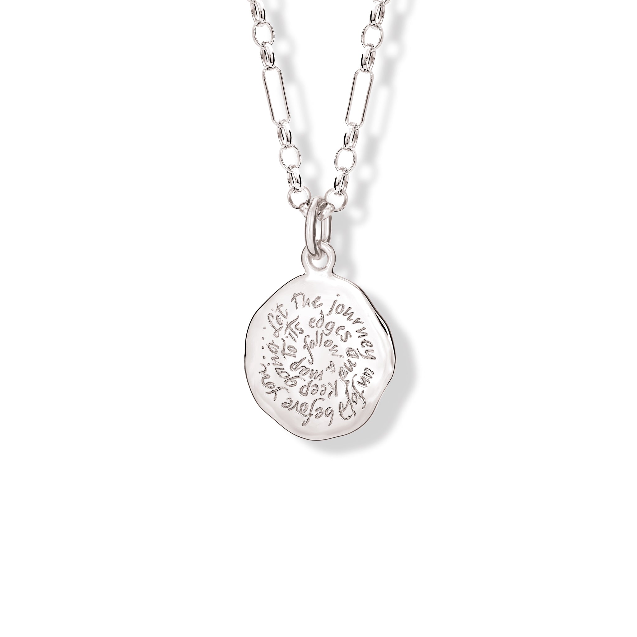 Handcrafted round sterling silver necklace pendant engraved with the quote, 'Follow a map to its edges. Let the journey unfold before you.'