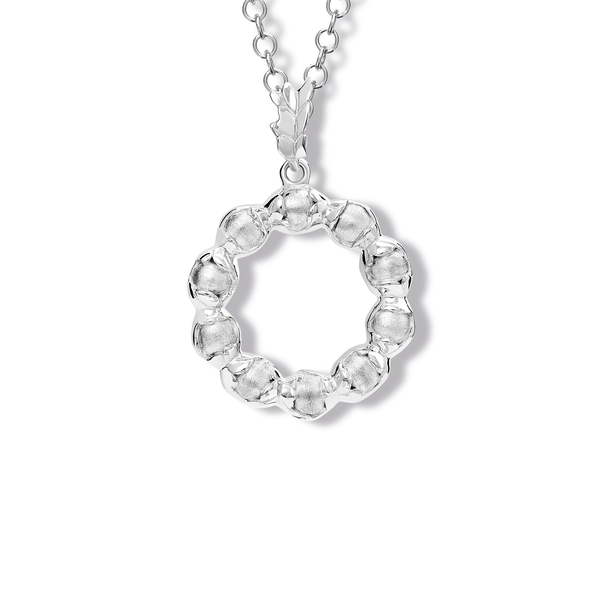 Handcrafted sterling silver necklace pendant featuring beads wrapped in leaves.