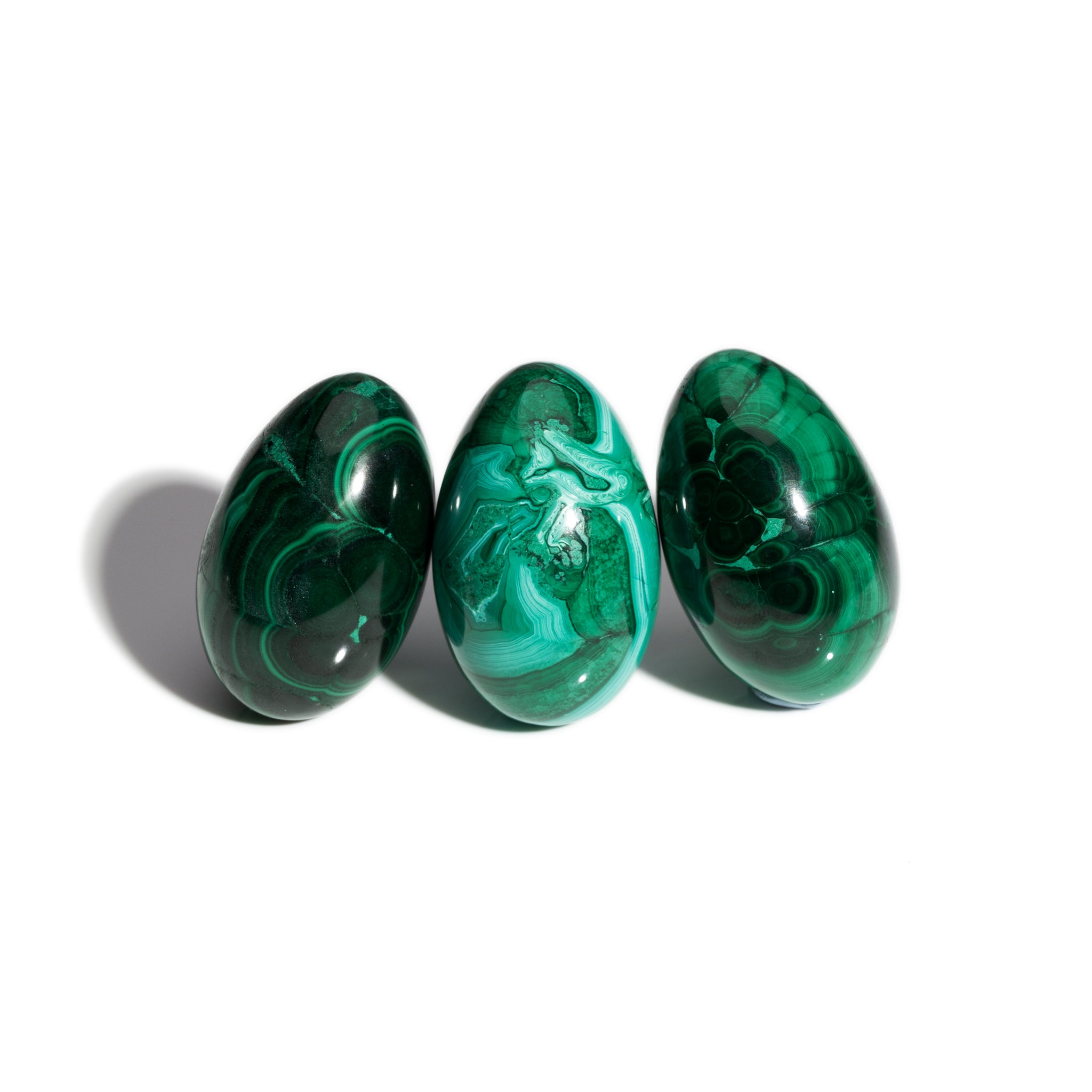 Three handcrafted gemstone eggs in the precious stone malachite.