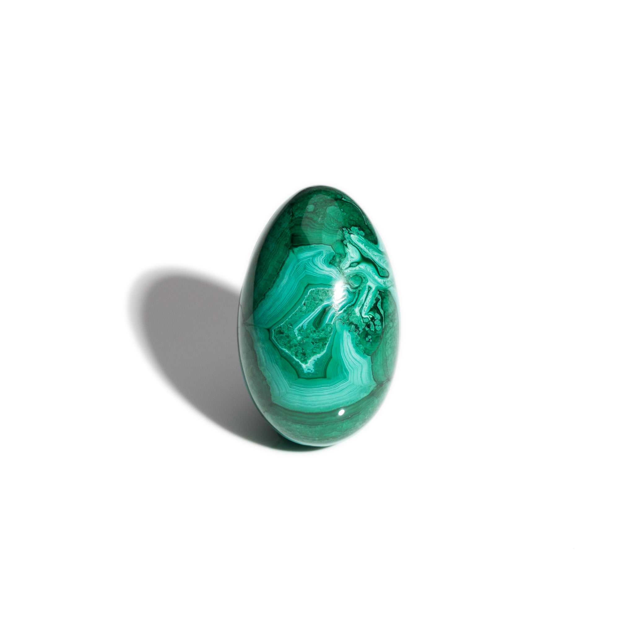 A handcrafted gemstone egg in the precious stone malachite.