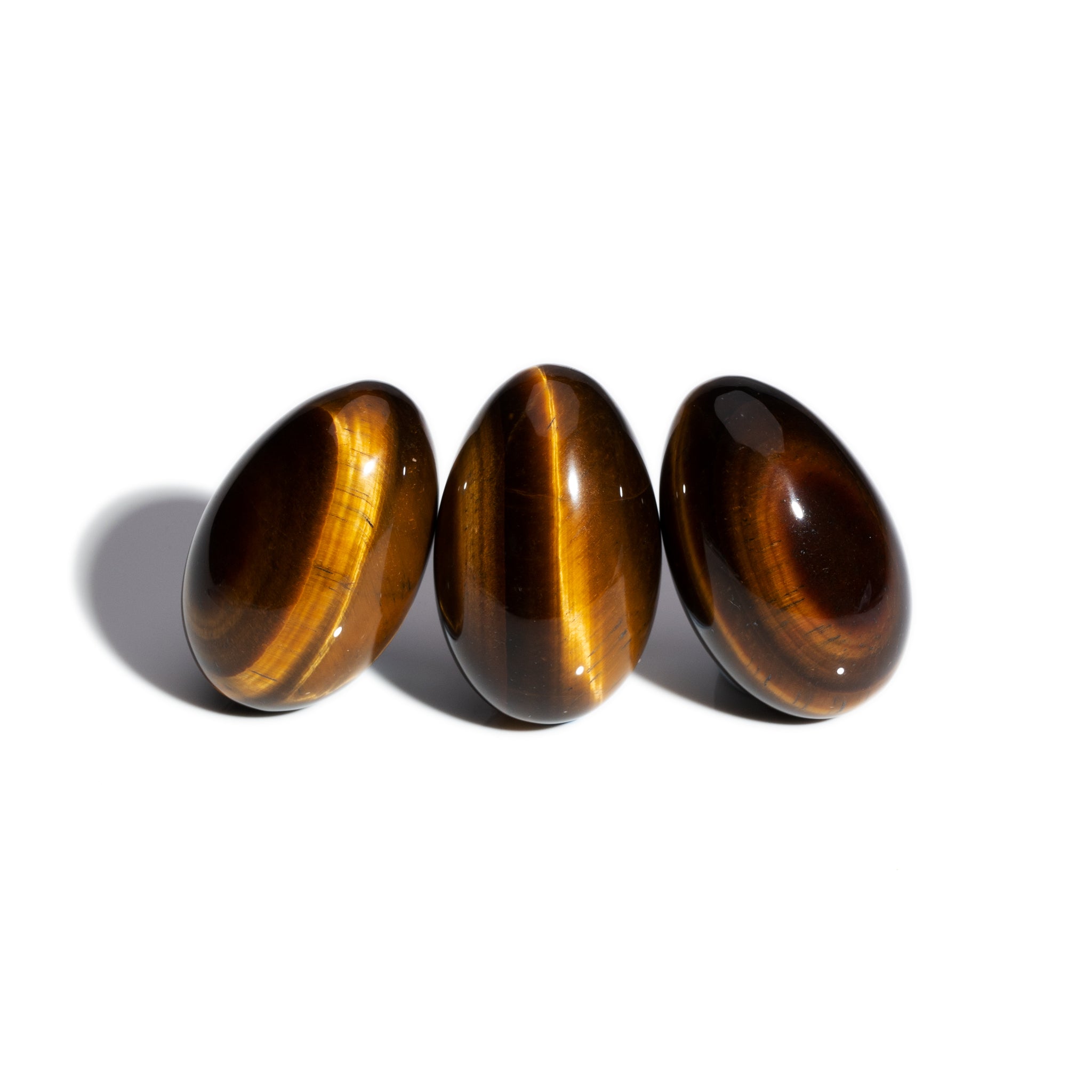 Three handcrafted gemstone eggs in the precious stone tiger's eye.