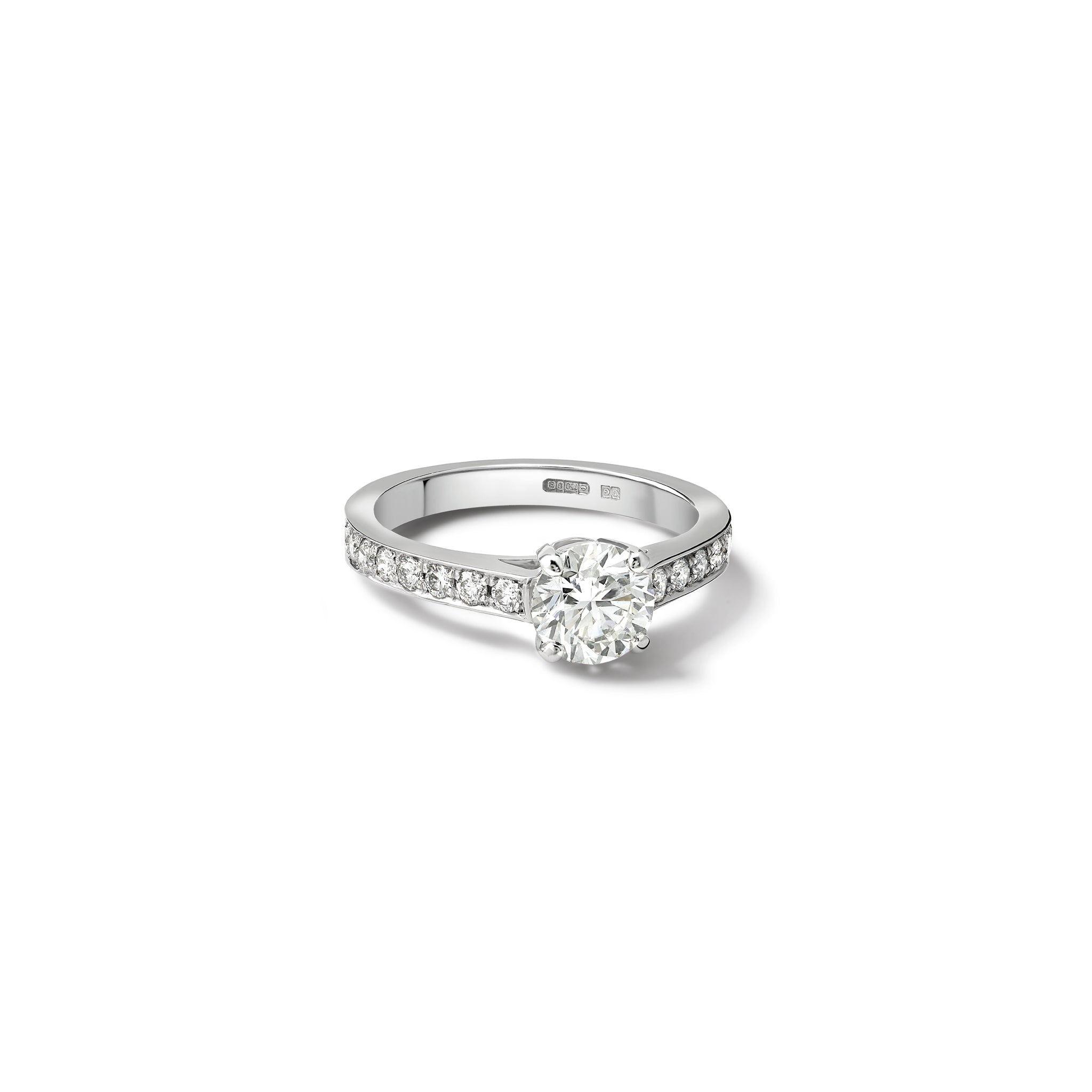 Handmade 18ct white gold engagement ring featuring a round central diamond with smaller diamonds embedded along the band.