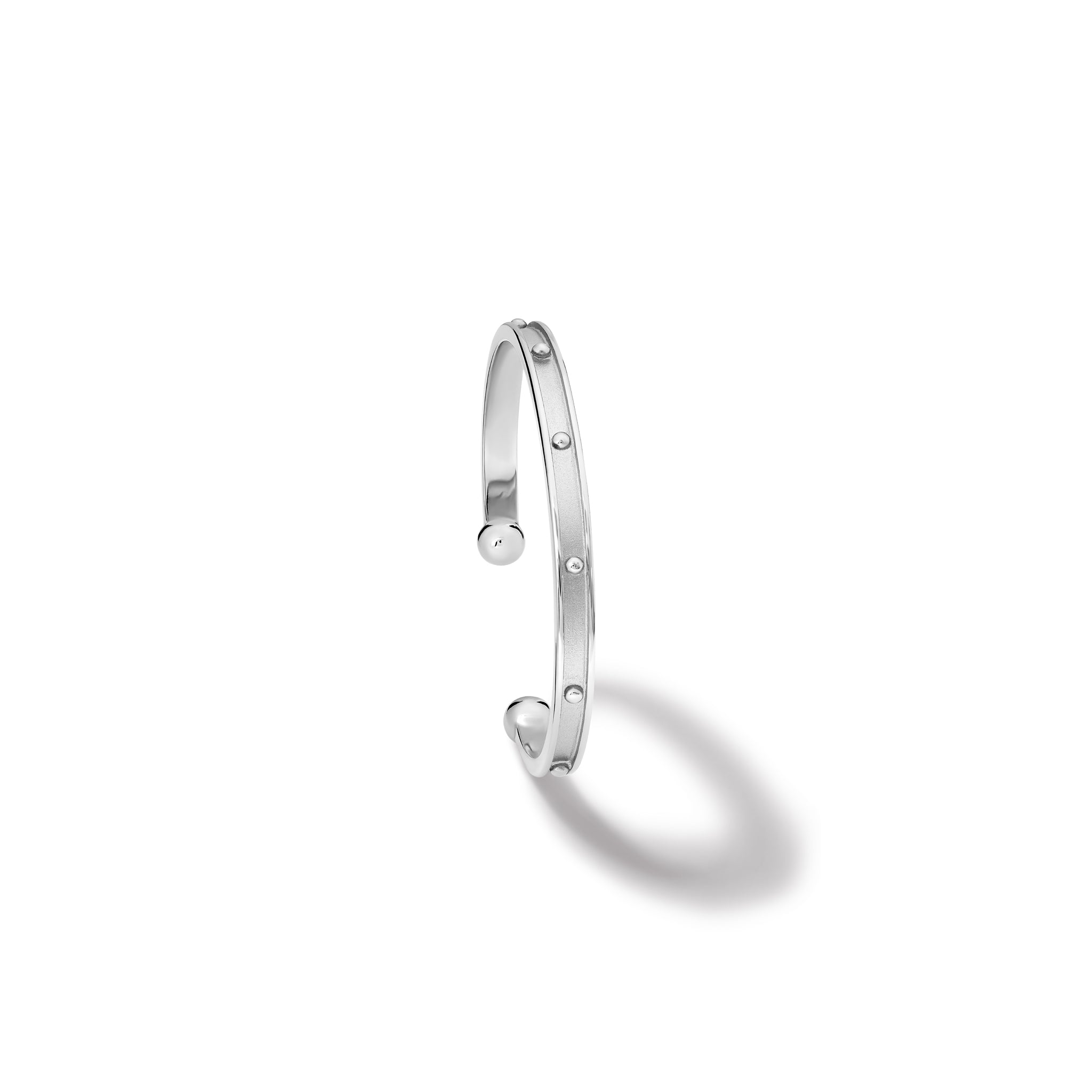 Handcrafted sterling silver bracelet cuff with evenly spaced, protruding round dots.