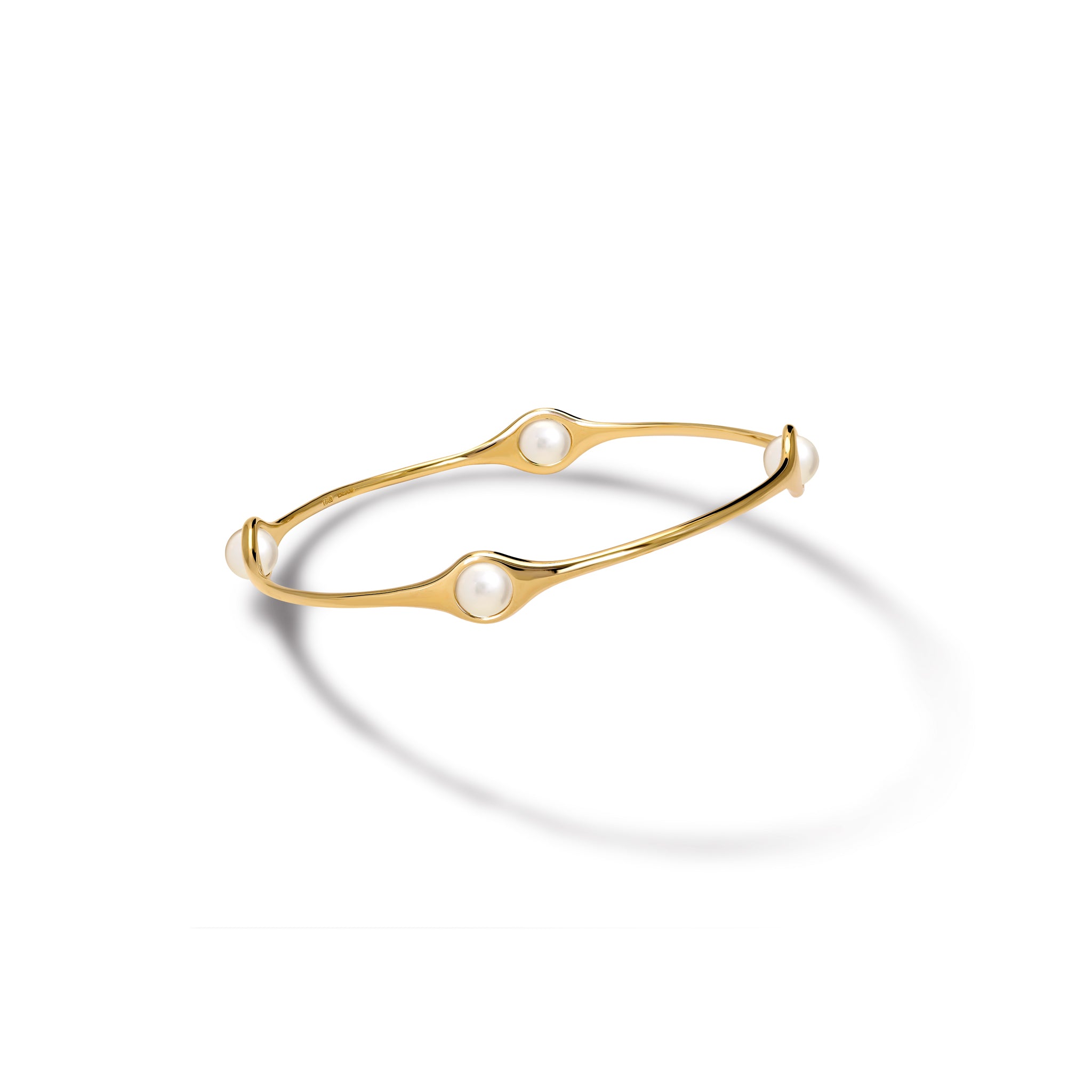 Handcrafted yellow gold bangle featuring four pearls.