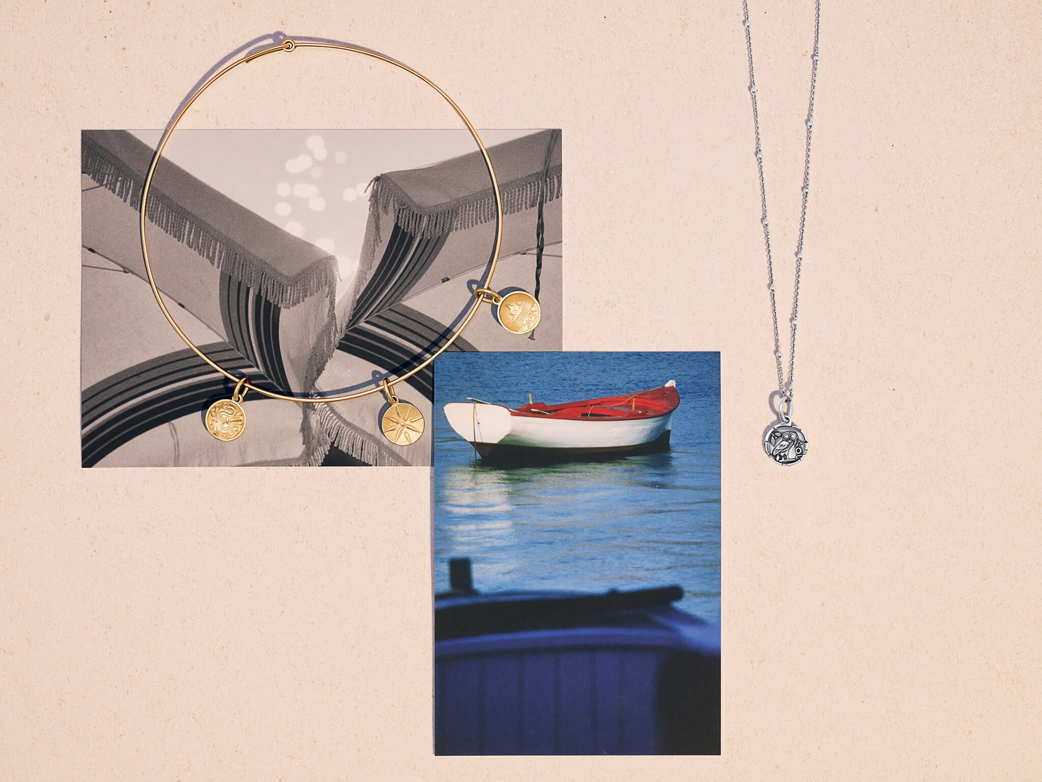 Still life image of Cassandra's Medallion charms shown with postcards from her new collection: Greece.