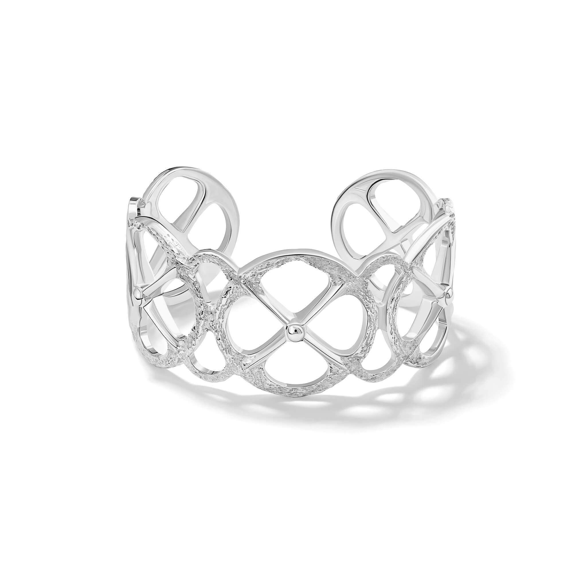 Handcrafted sterling silver cuff bracelet with a circular motif and a cross in the middle.