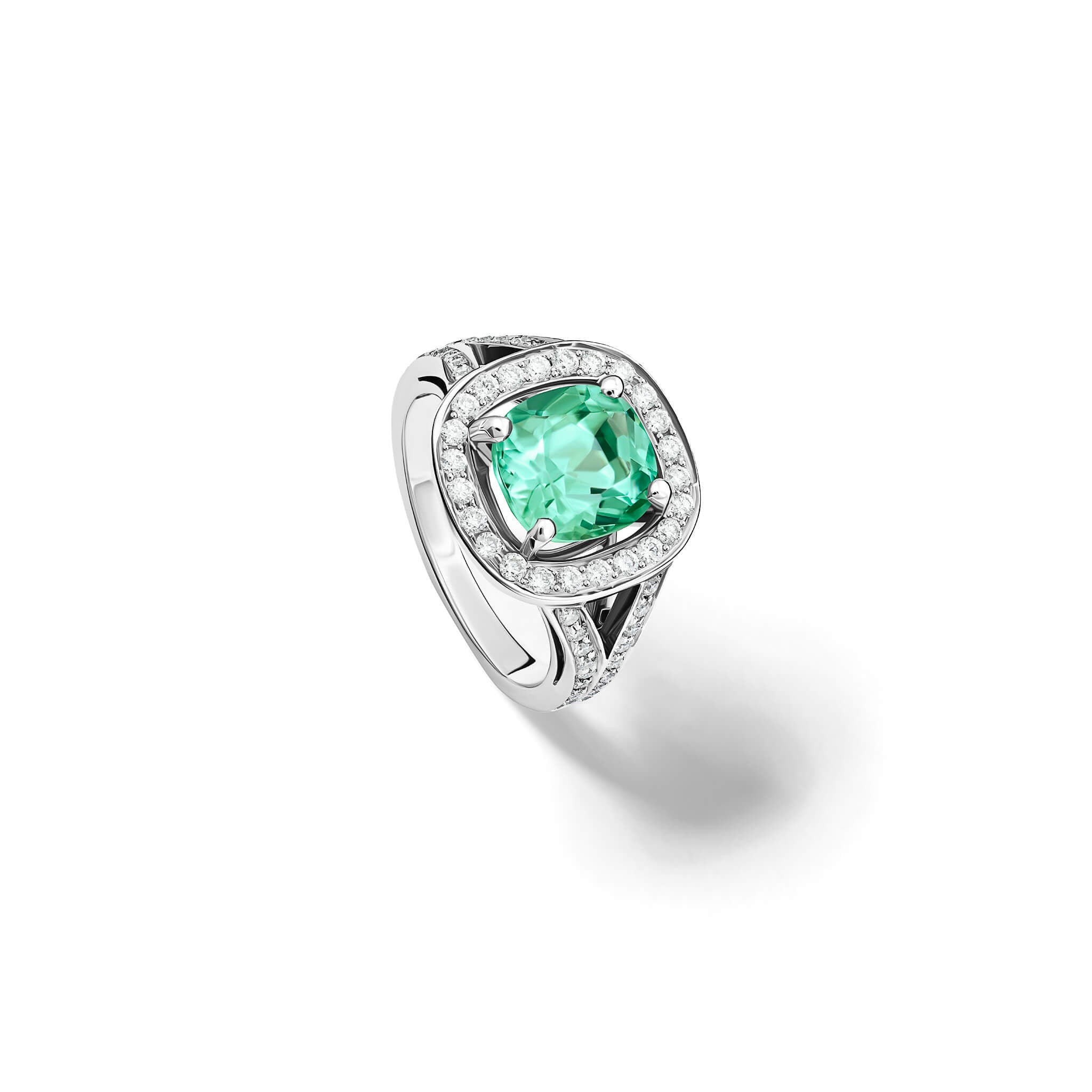 Handcrafted 18ct white gold engagement ring featuring a large, cushion-cut mint tourmaline surrounded by a halo of small diamonds and smaller diamonds embedded along the band.