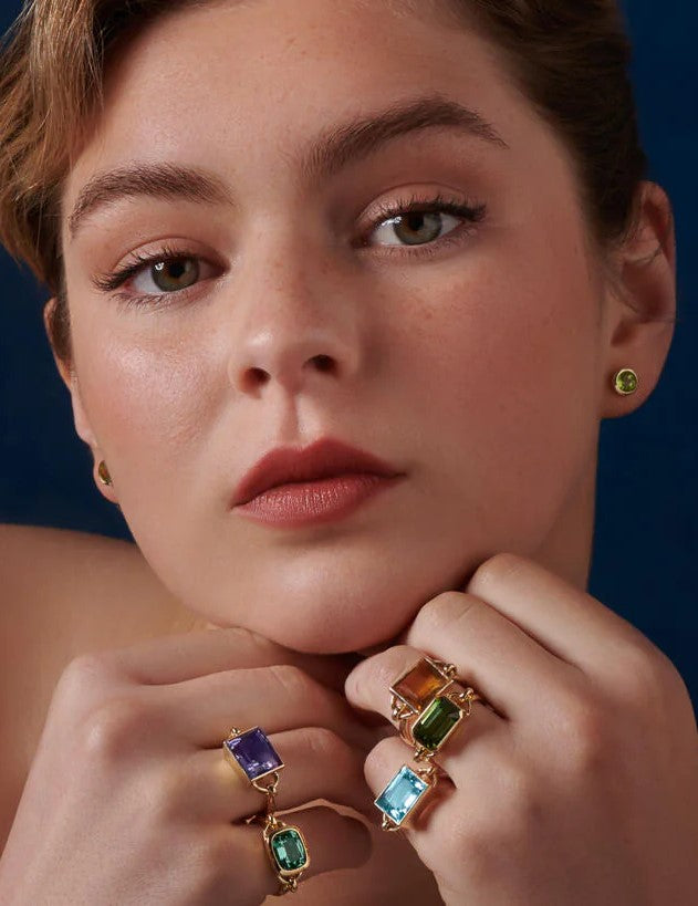 Model wearing handcrafted yellow gold rings featuring baguette cut precious gemstones, the perfect cocktail rings.