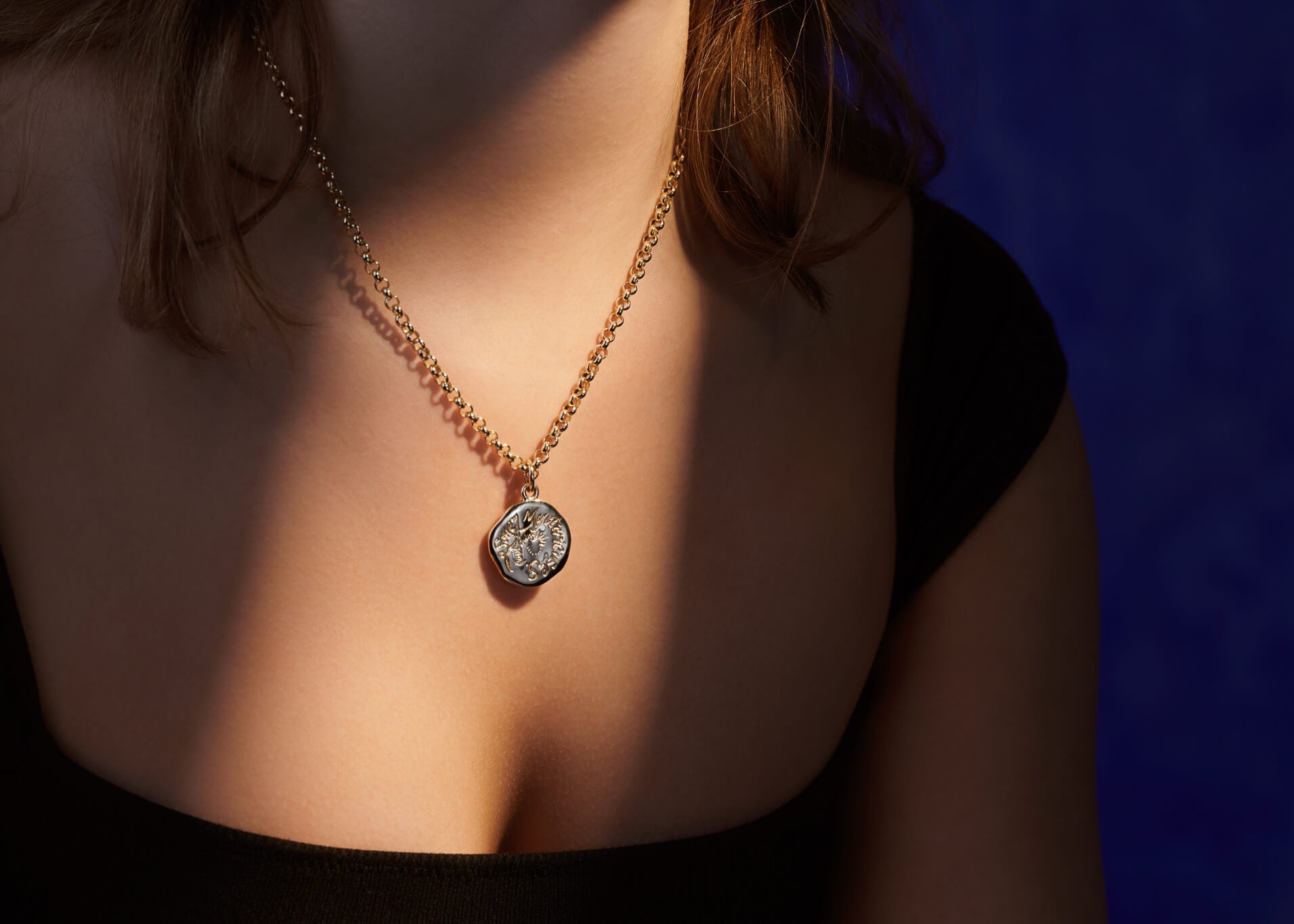 Model wears handcrafted yellow gold quote pendant.