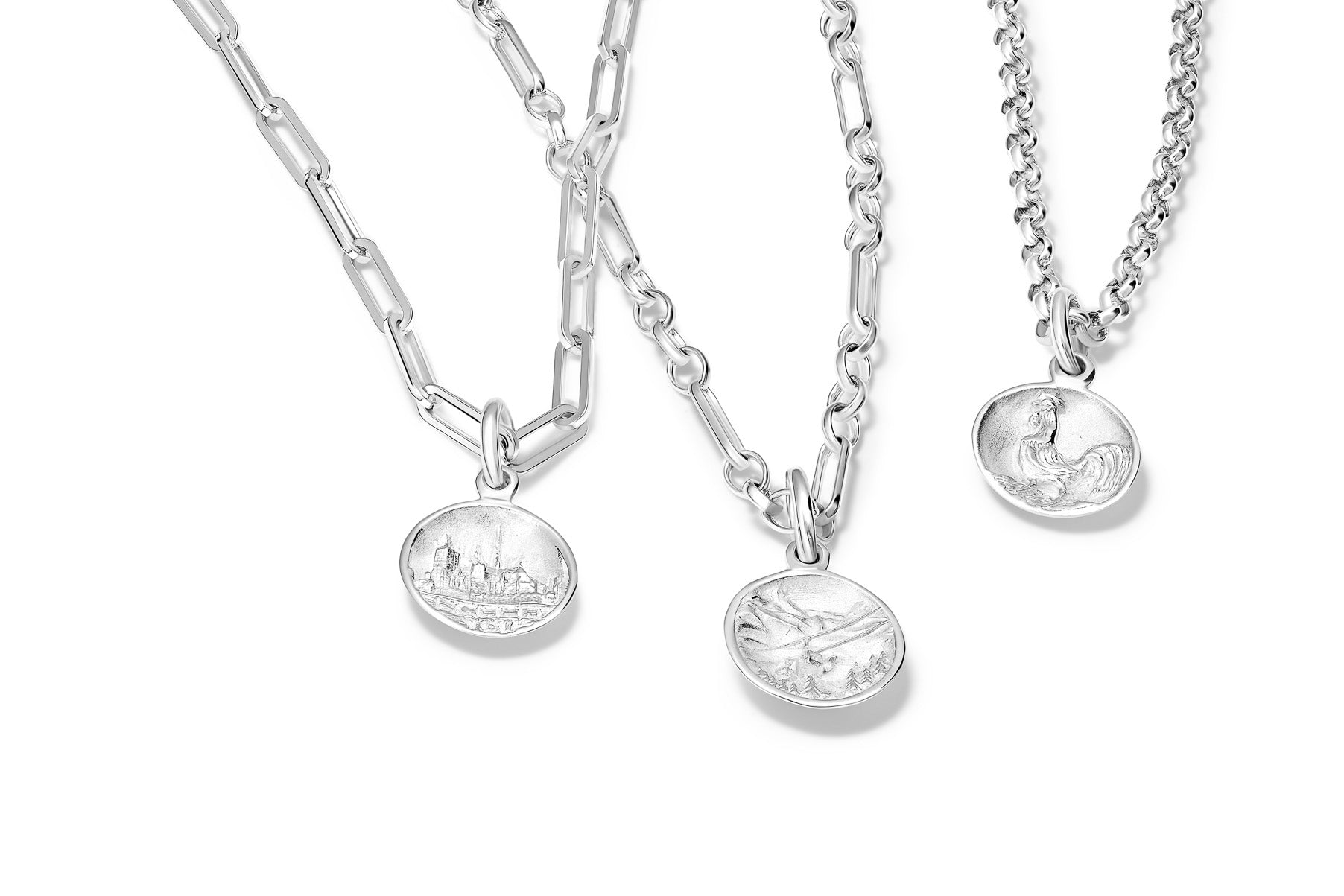 Handcrafted chain necklaces in sterling silver with different links featuring round sterling silver necklace pendants 'en relief' with icons of French culture.