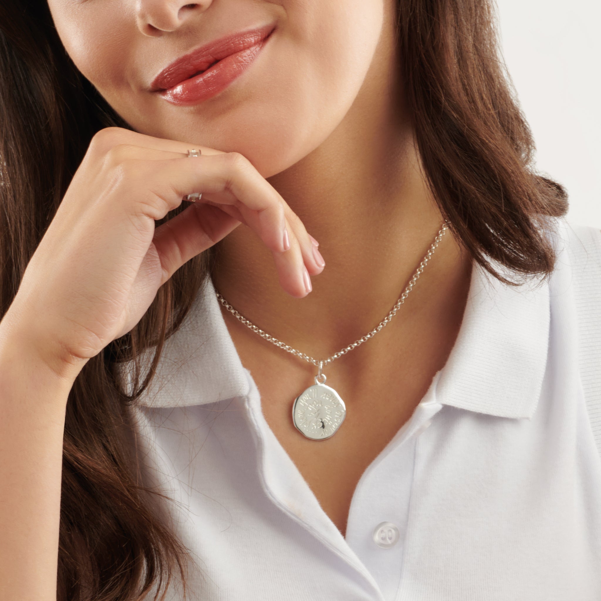 Model wearing a handcrafted round sterling silver necklace pendant engraved with a quote.