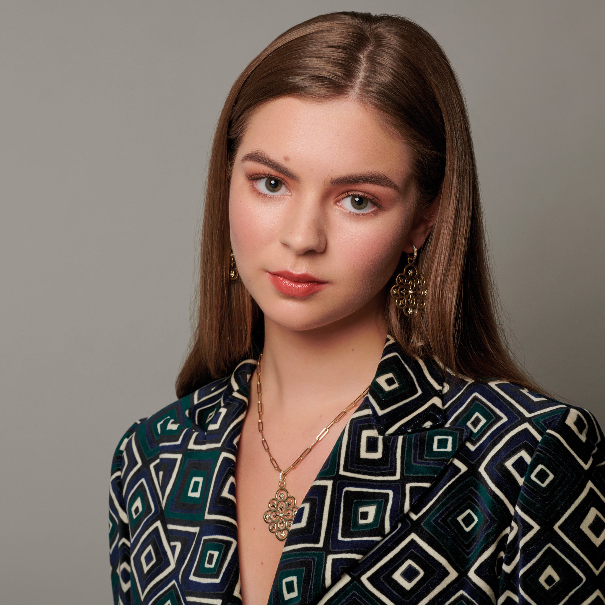 Model wearing a handcrafted yellow gold necklace pendant and earring drops featuring the intricate Mexican Tree of Life design with diamonds.
