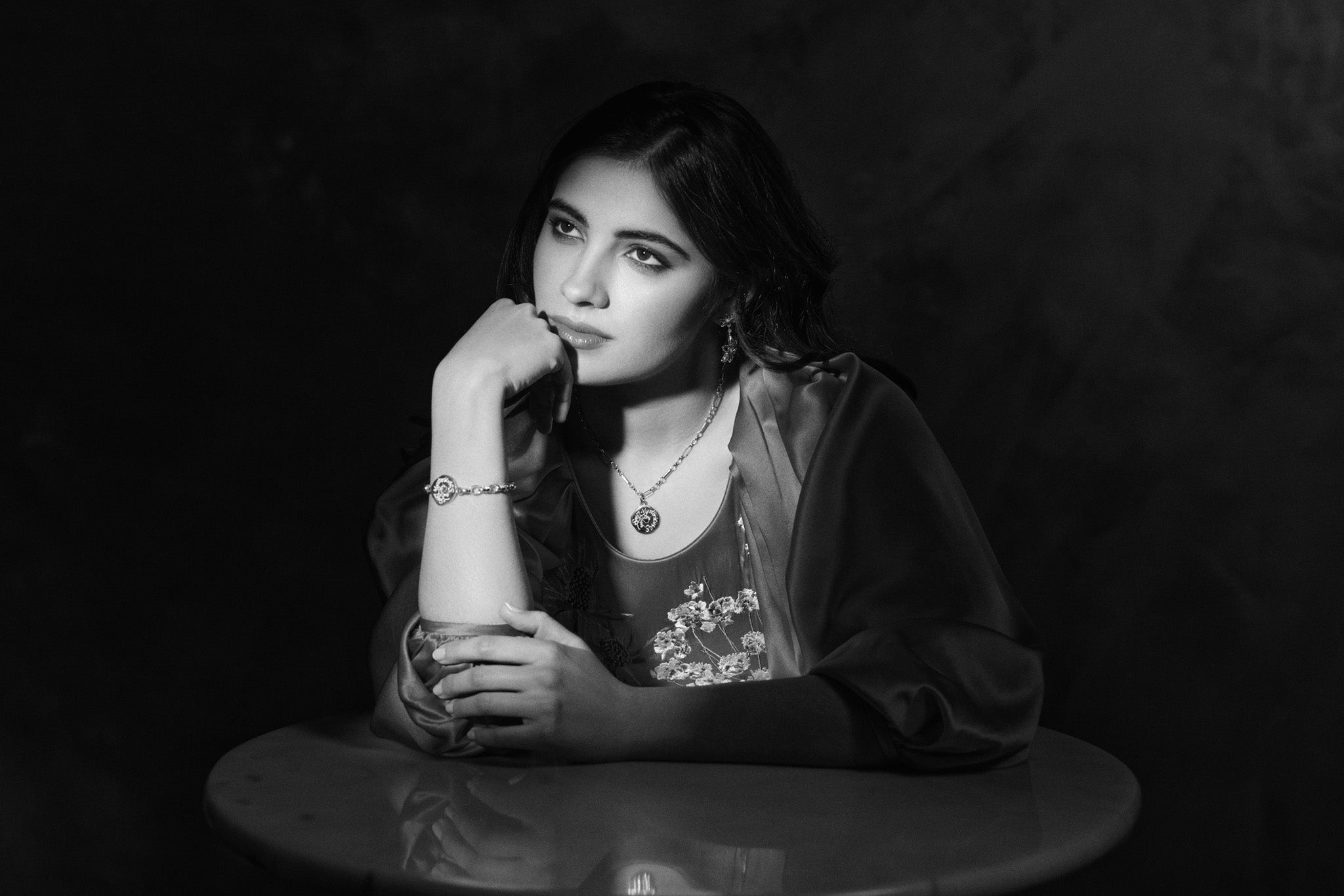Model wearing handcrafted round gold jewellery featuring pendants engraved with inspirational quotes.
