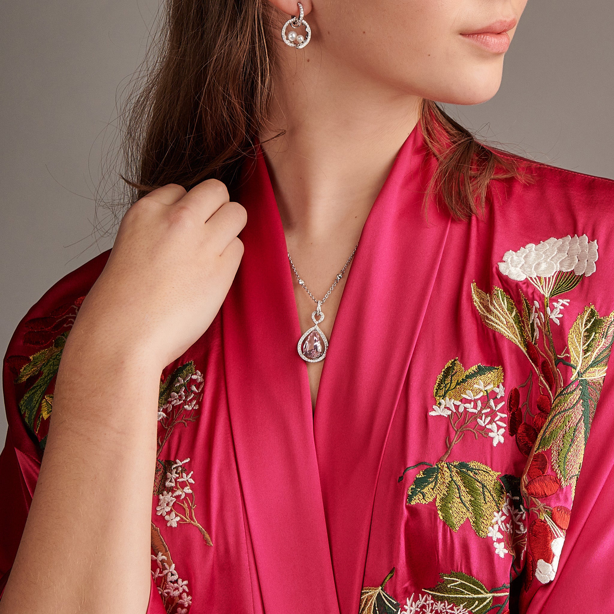 Model wearing a handcrafted 18ct white gold necklace pendant featuring a central morganite surrounded by diamonds.