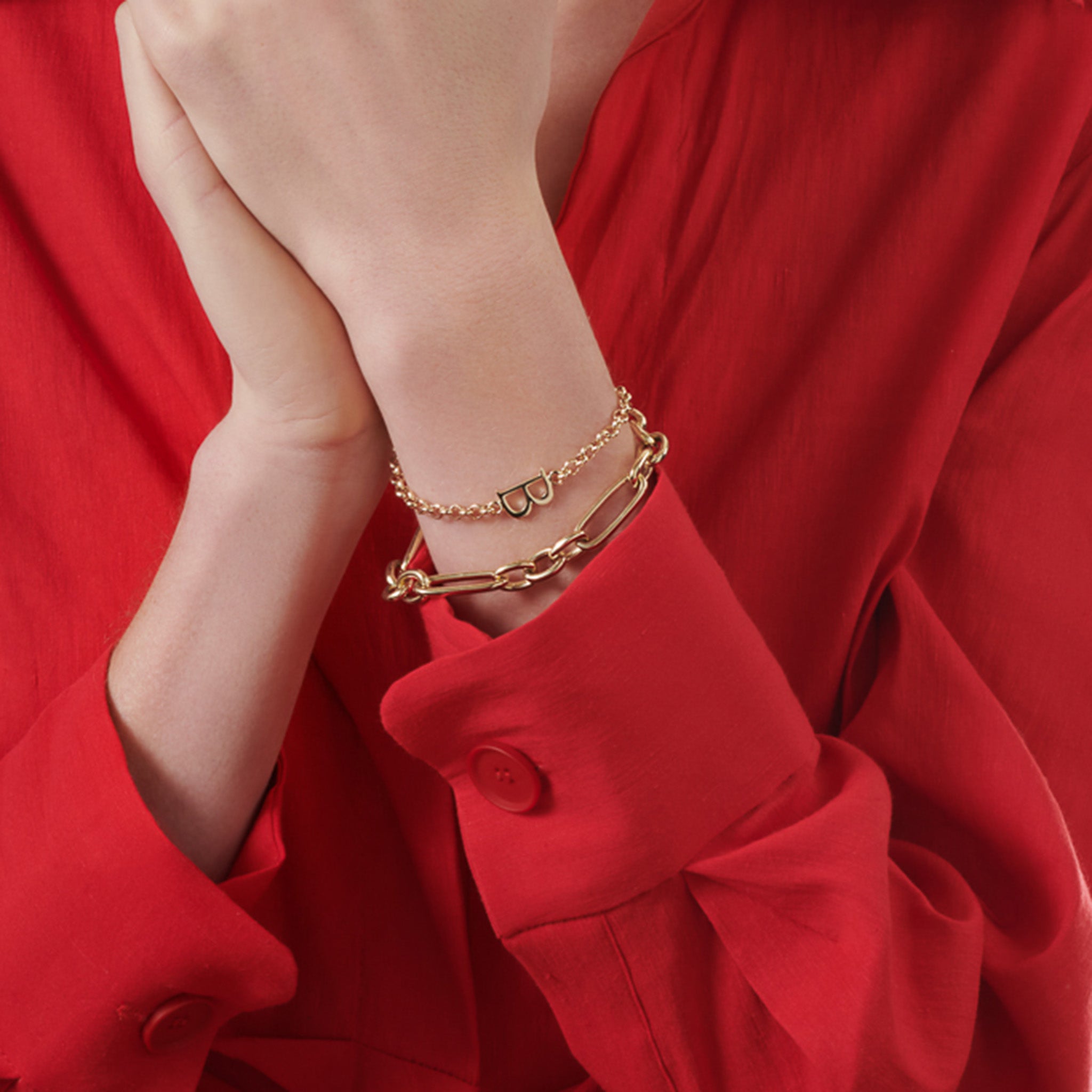 Model wearing a handcrafted yellow gold link bracelet featuring chunky round and rounded rectangular links interconnected.