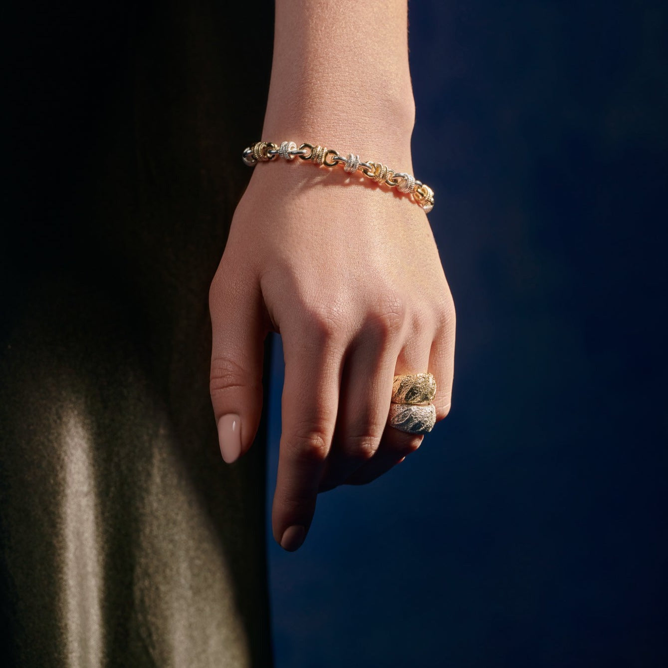Model wearing a handcrafted sterling silver ring designed with the intricate pattern and texture of a French baguette.
