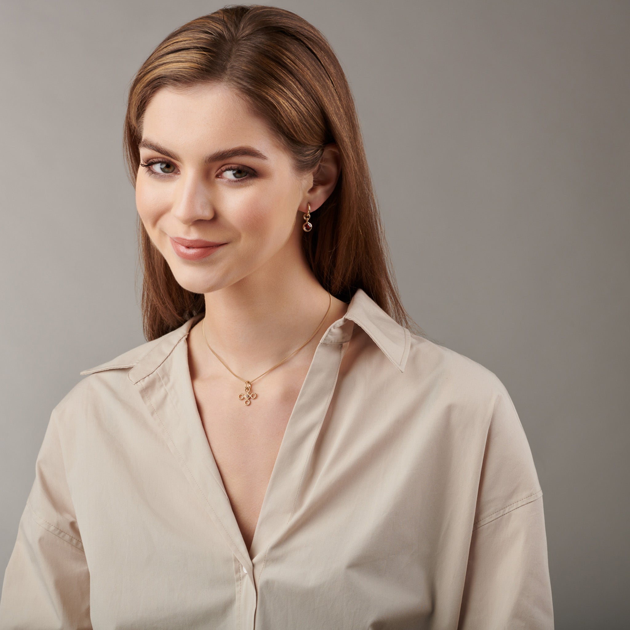 Model wearing handcrafted yellow gold earring drops with  garnet.