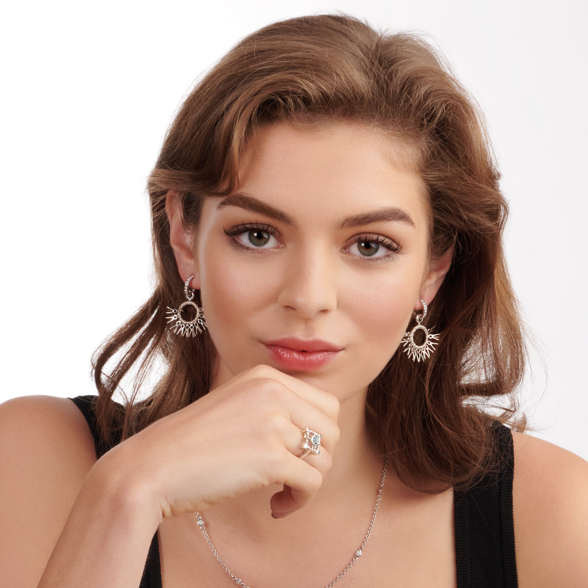 Model wearing handcrafted sterling silver earrings in the shape of dried palm fronds from Morocco.