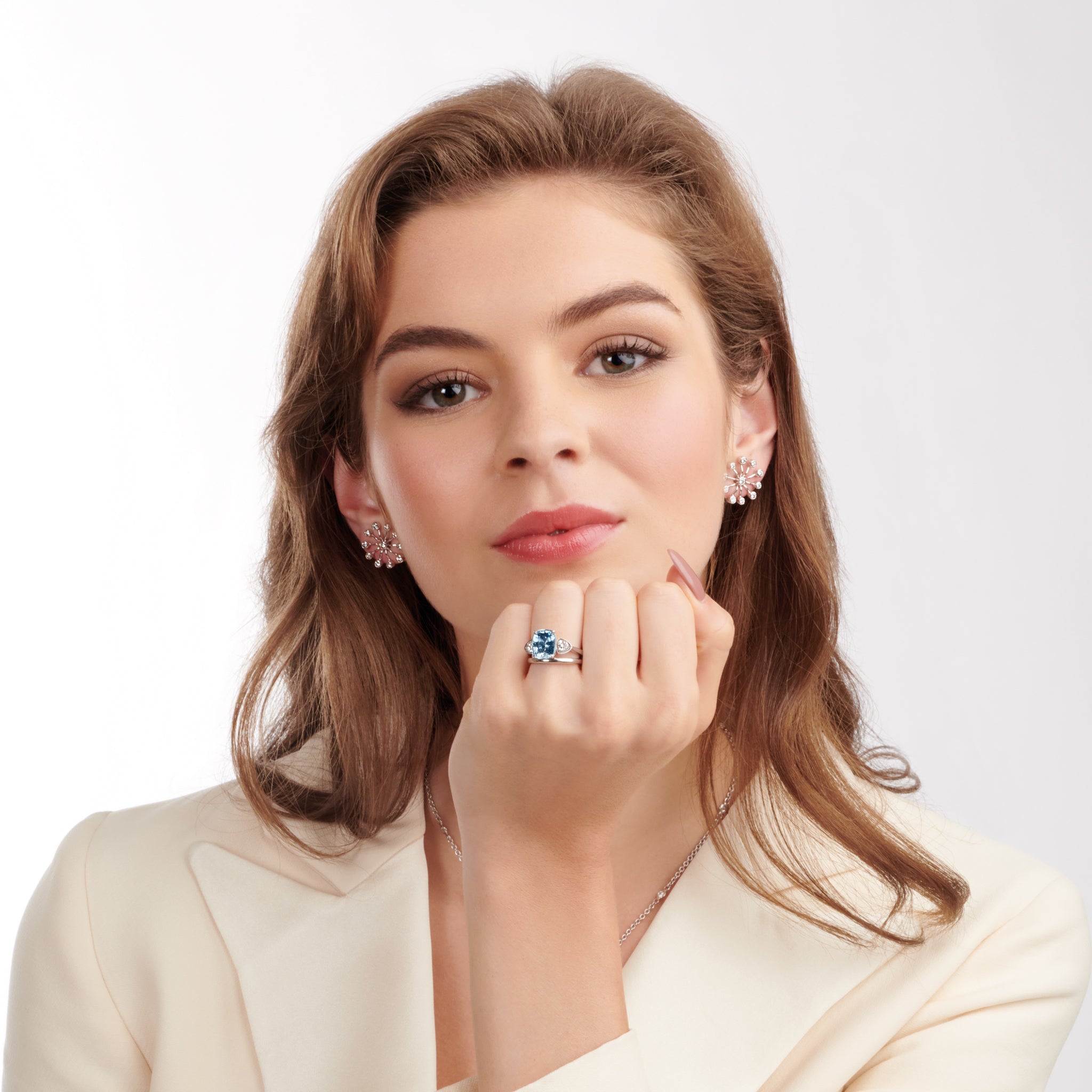 Model wearing handcrafted 18ct white gold earrings inspired by the delicate spurs of an astrantia flower, with diamonds set at the tip of each spur.