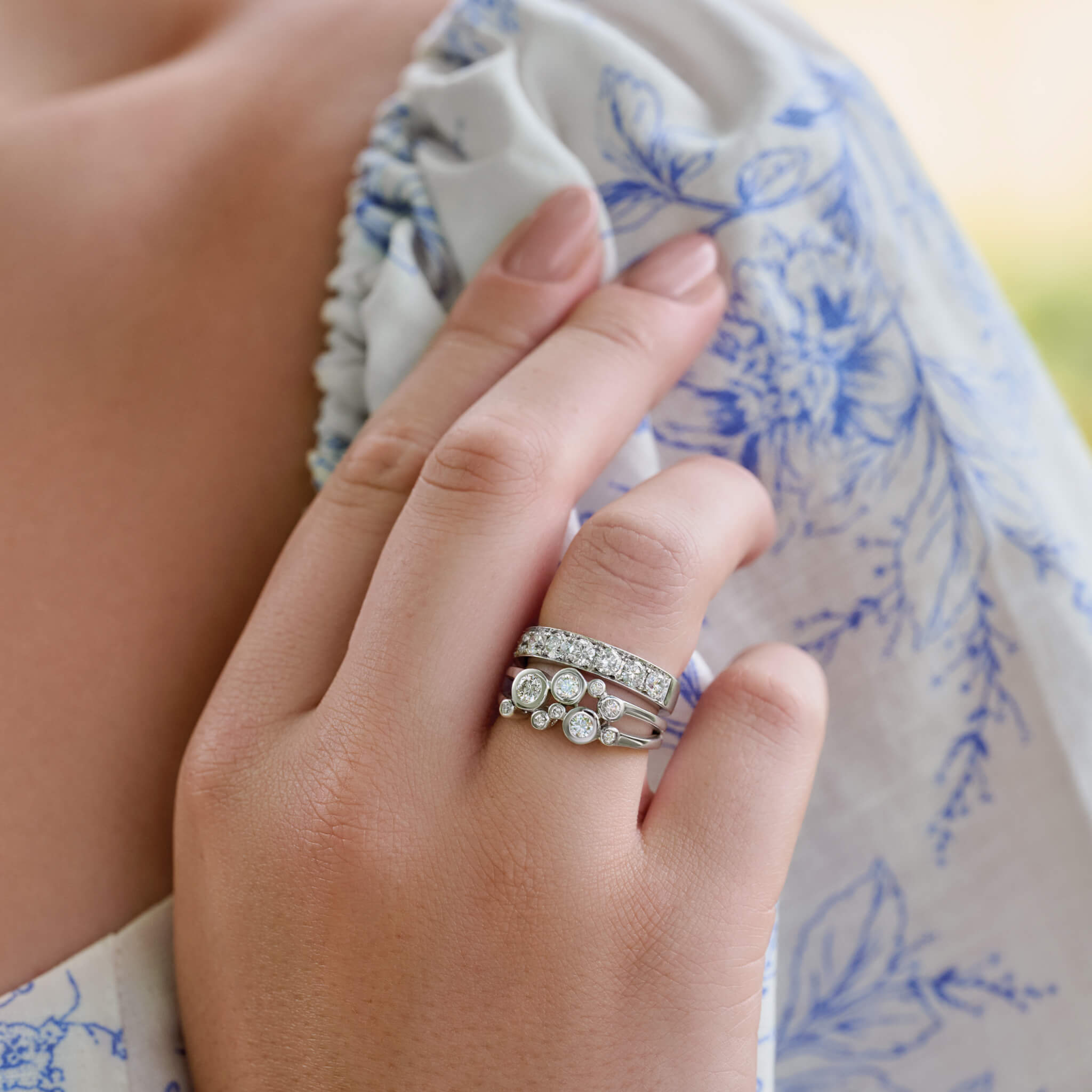Model wears handcrafted 18ct white gold ring featuring different sized round precious gemstones.