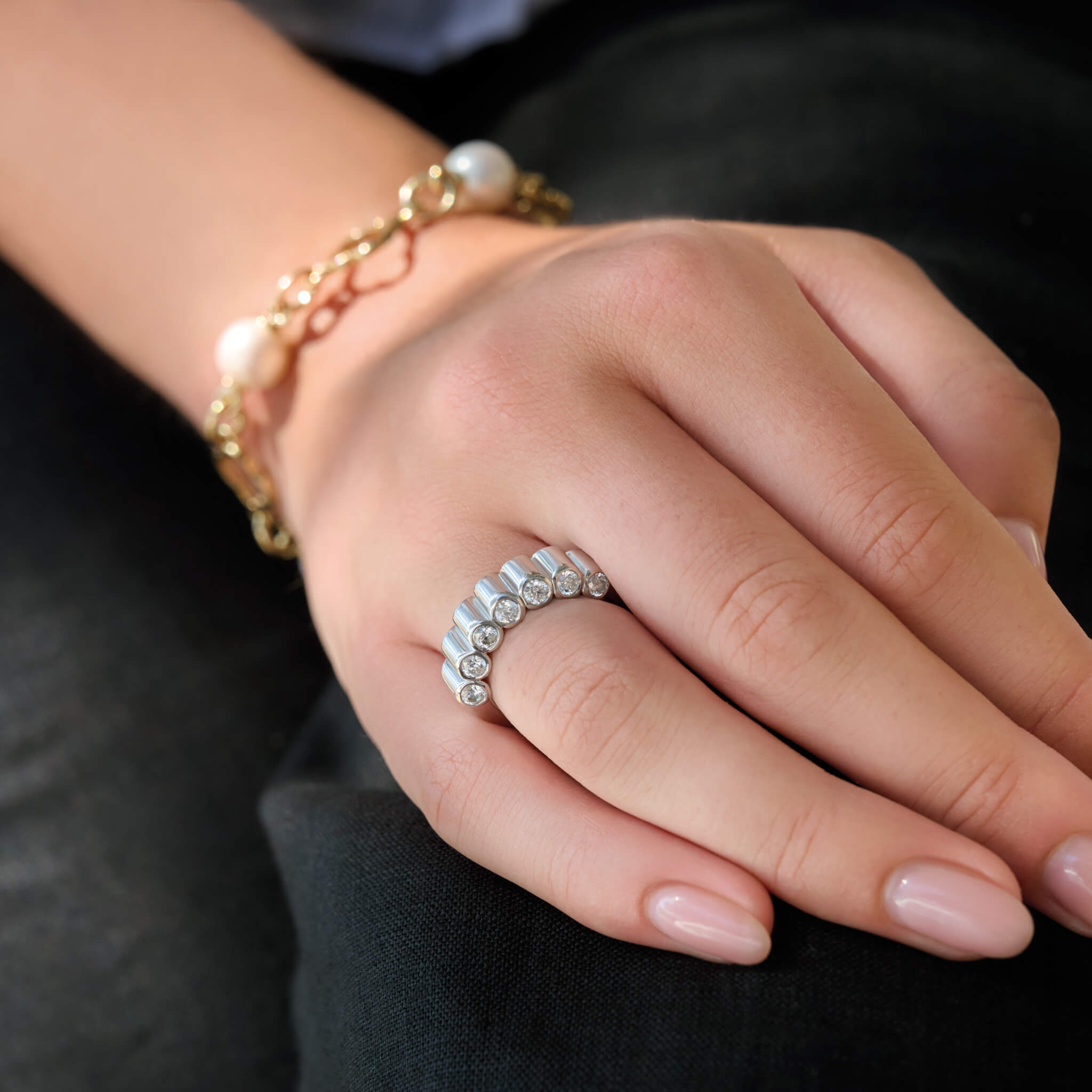 Model wears handcrafted 18ct white gold eternity ring with diamonds on the side of the shank and smooth ridges along the top.