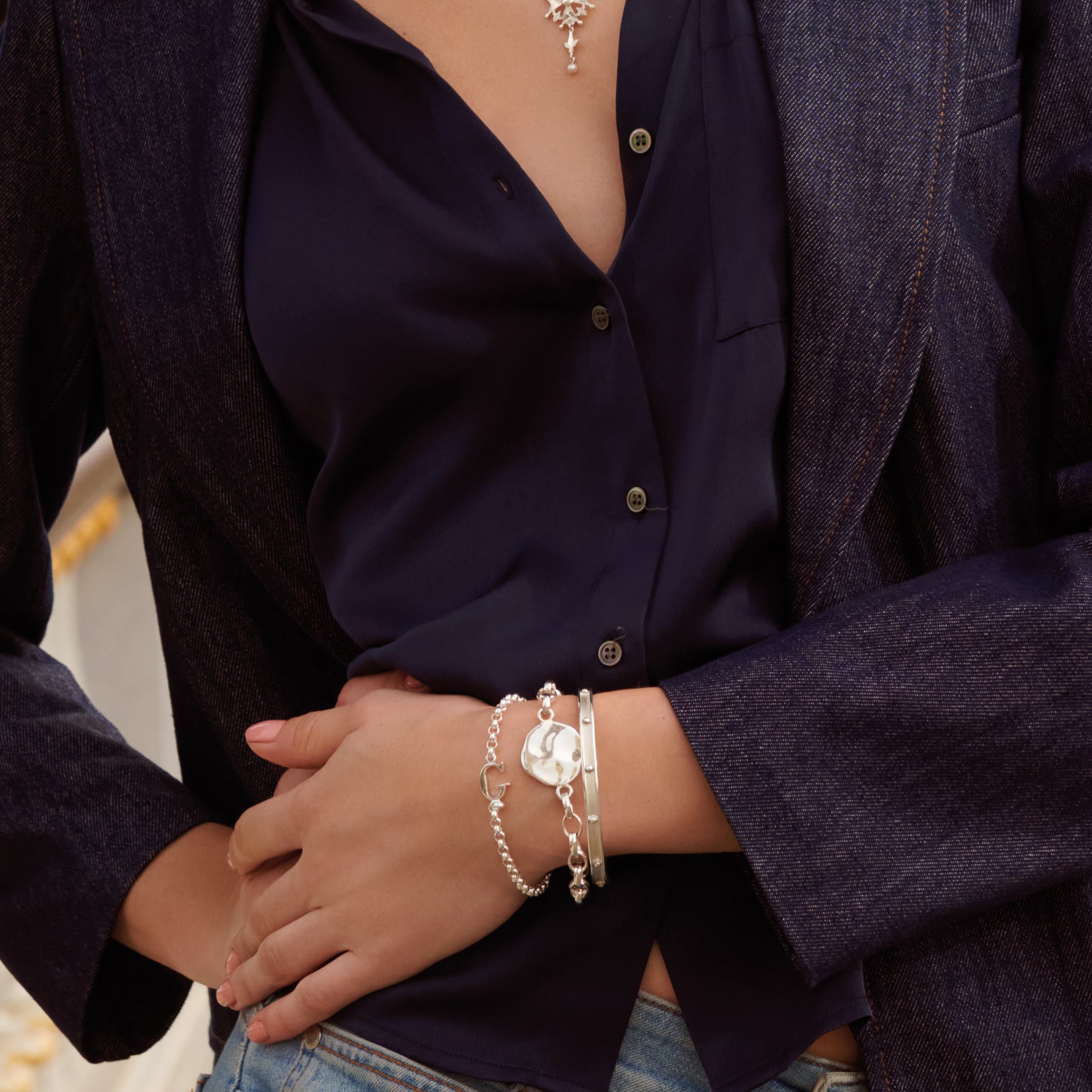 Model wearing a handcrafted sterling silver link bracelet featuring a pendant engraved with a quote.