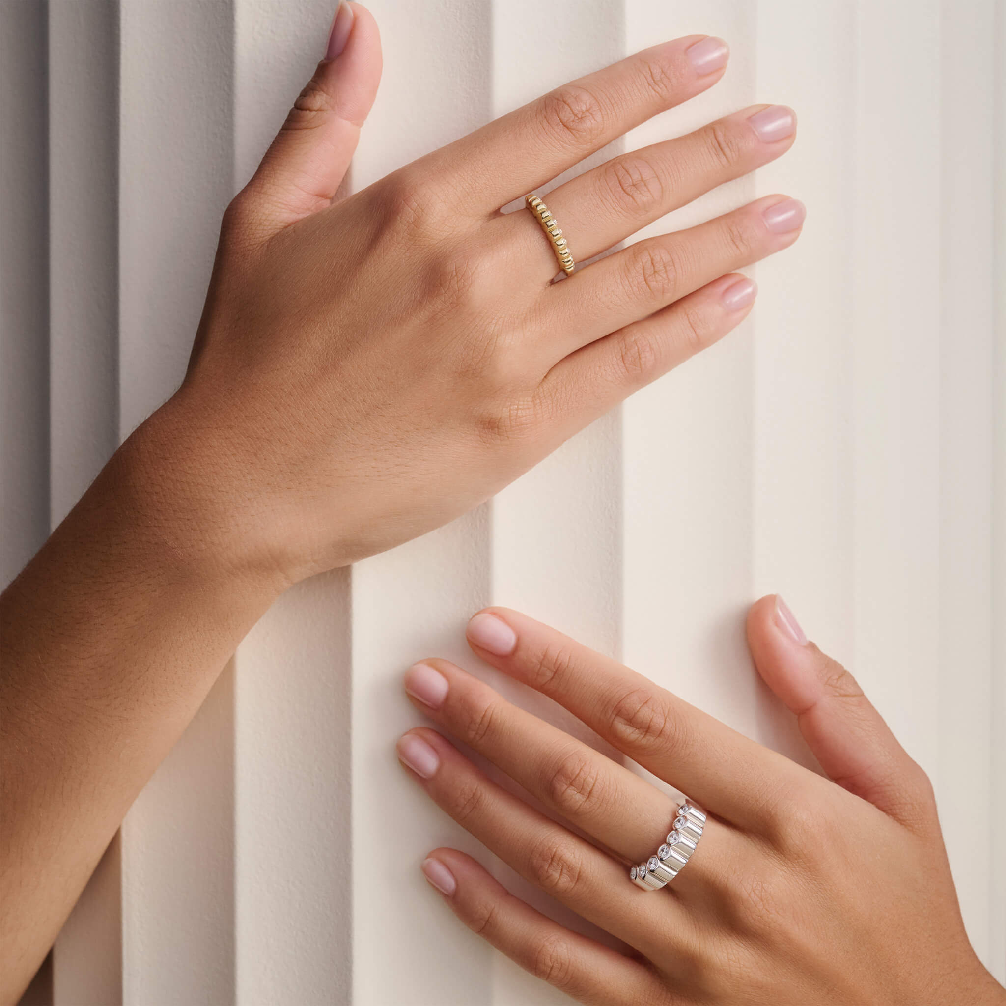 Model wearing handcrafted eternity rings in yellow gold and silver with diamonds