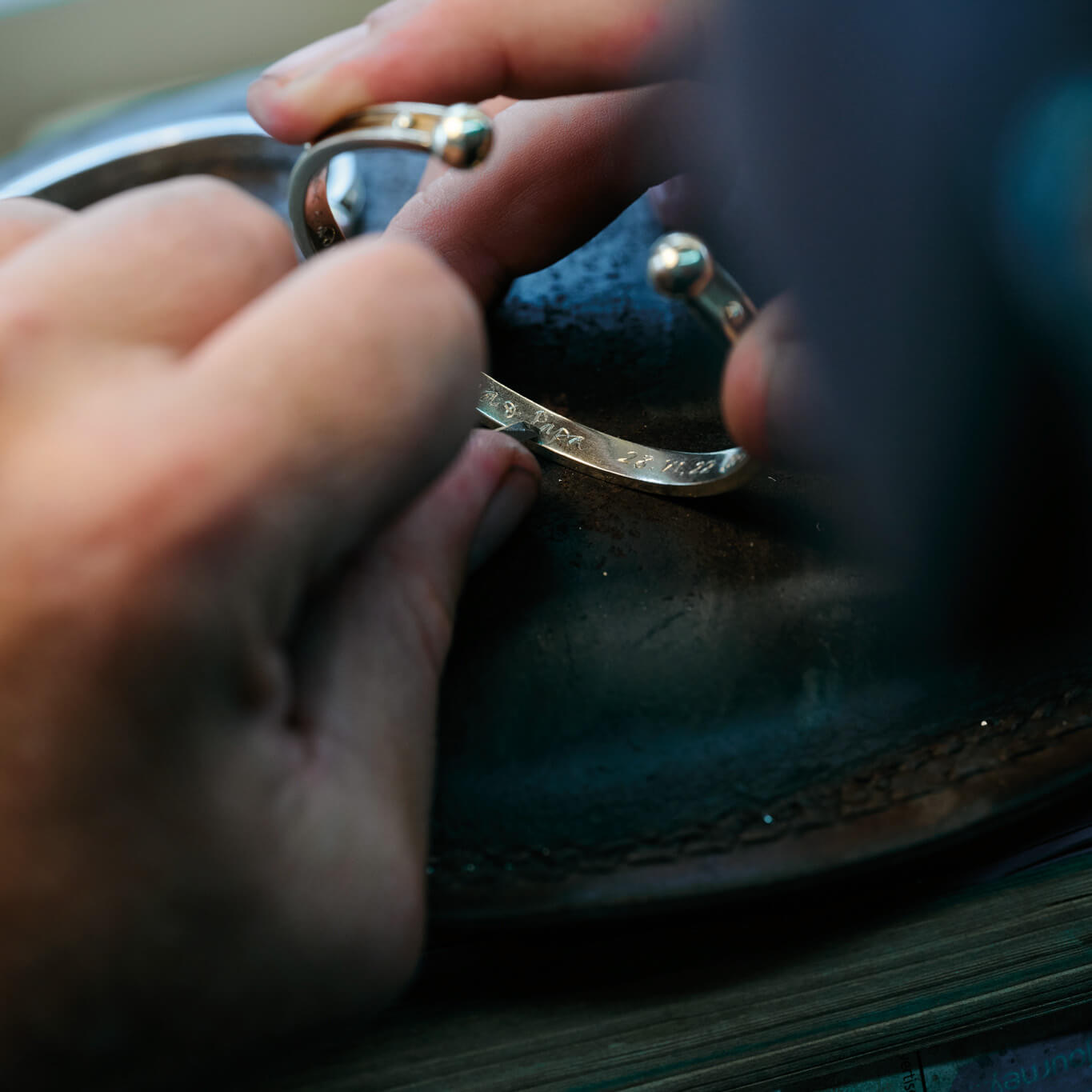 18ct yellow gold bracelet cuff being expertly hand engraved.