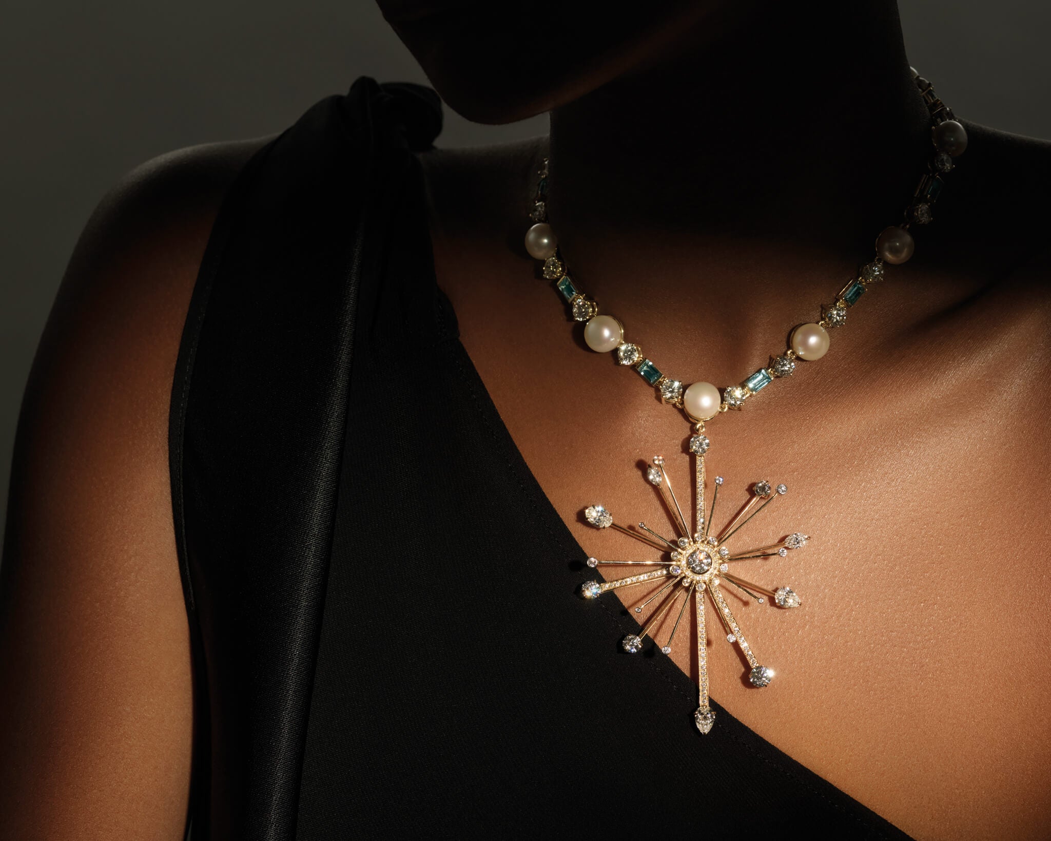 Model wearing the feather plume necklace and brooch with diamonds, pearl and aquamarine