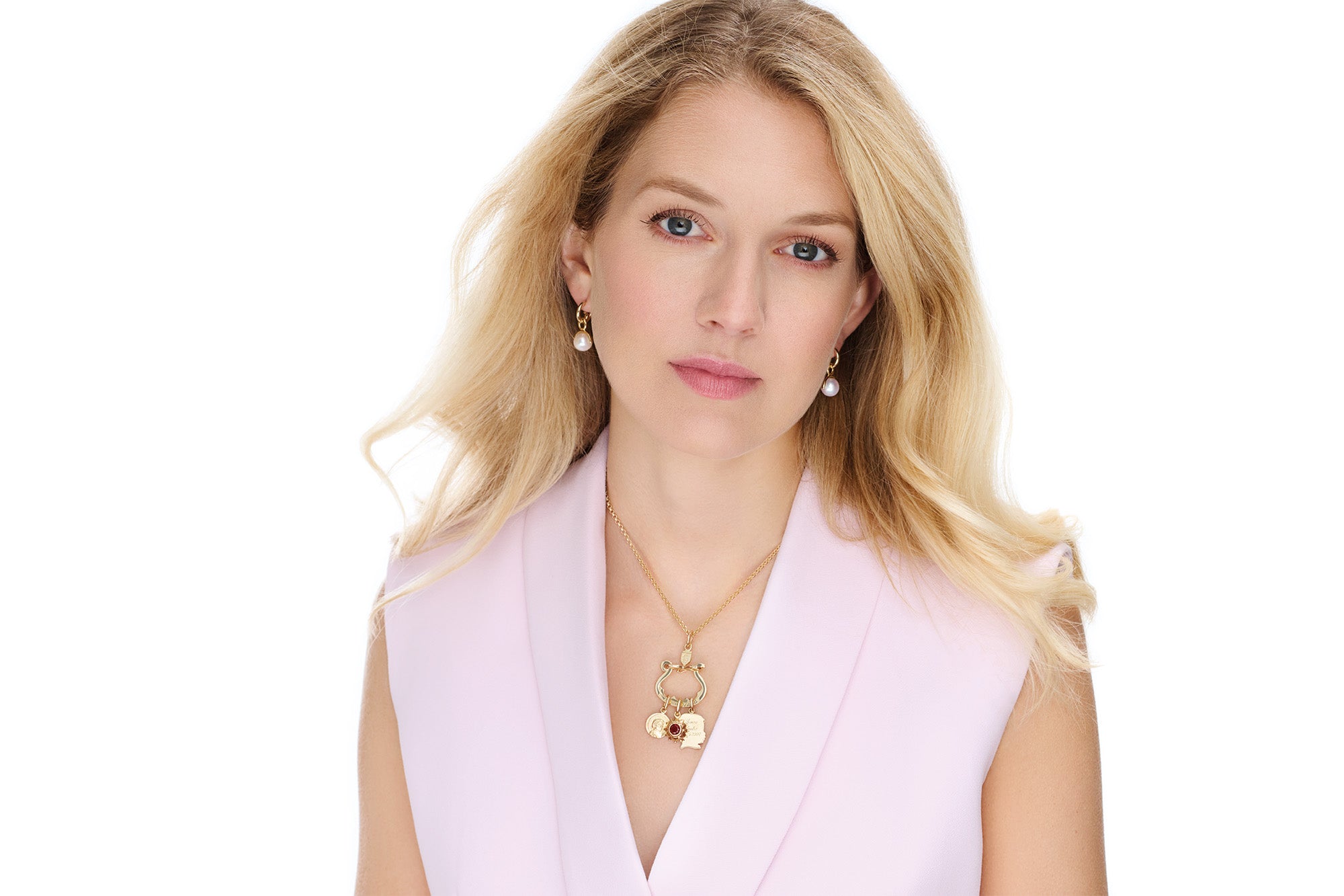Model wearing handcrafted yellow gold jewellery with three necklace pendants on a charm holder.