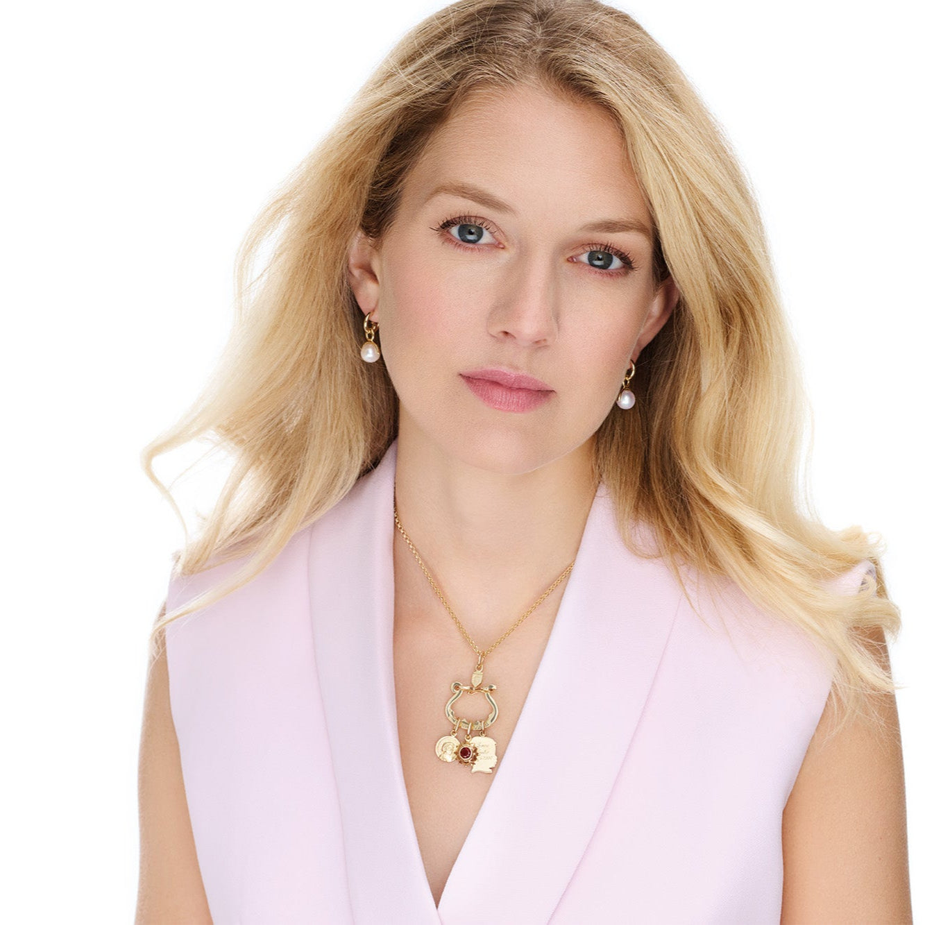 Model wearing handcrafted yellow gold jewellery with three necklace pendants on a charm holder.