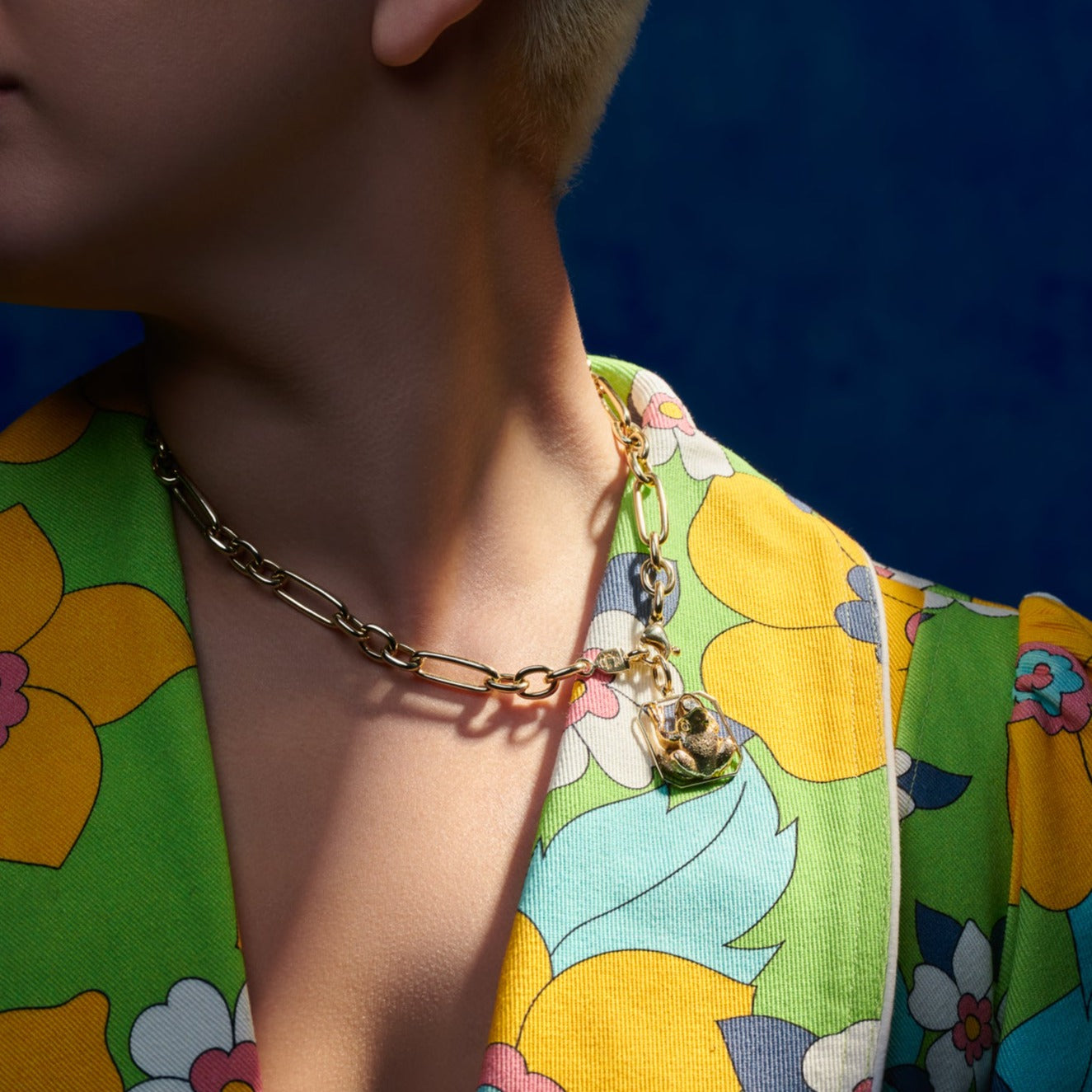 Model wearing a handcrafted yellow gold frog shaped necklace pendant with diamonds.