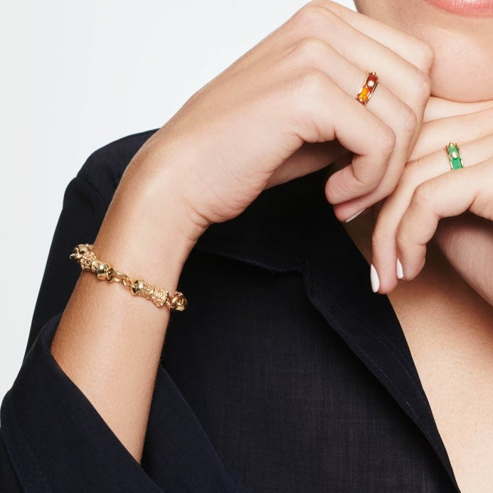 Model wearing a handcrafted yellow gold bracelet featuring textured column shapes with links.