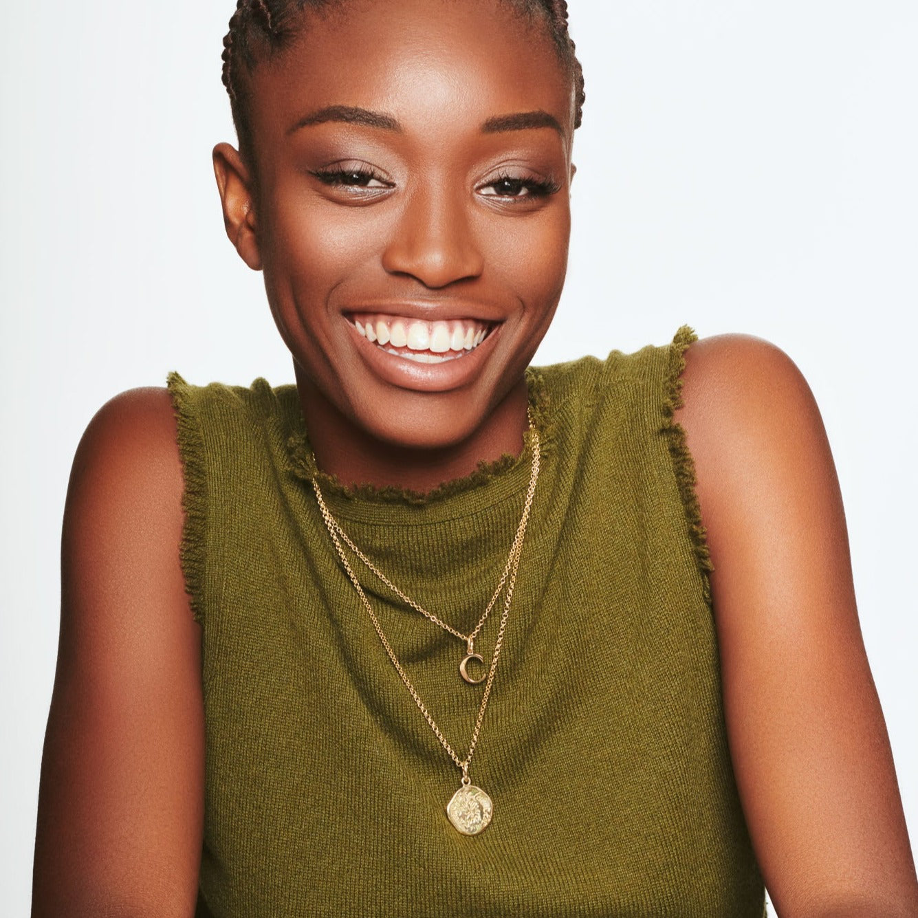 Model wearing a handcrafted round yellow gold necklace pendant engraved with a quote.