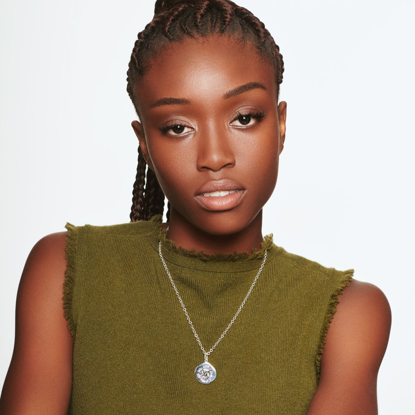 Model wearing a handcrafted round sterling silver necklace pendant engraved with a quote.