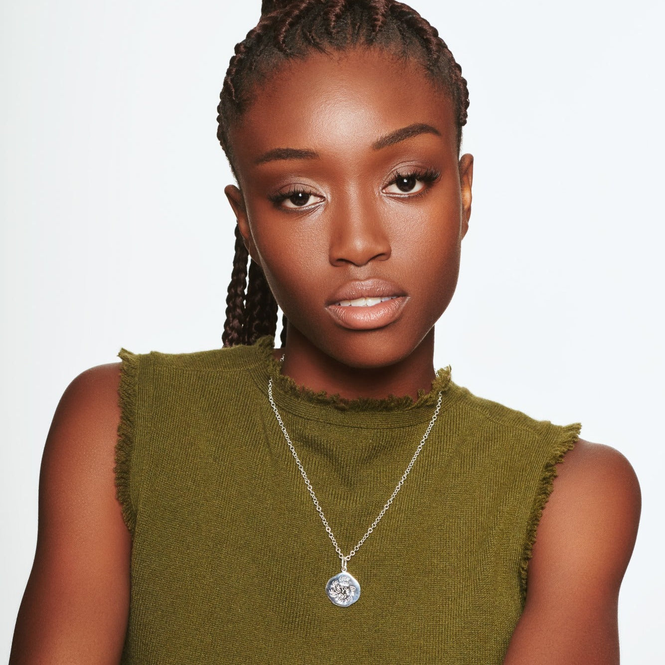 Model wearing a handcrafted round sterling silver pendant necklace engraved with a quote.