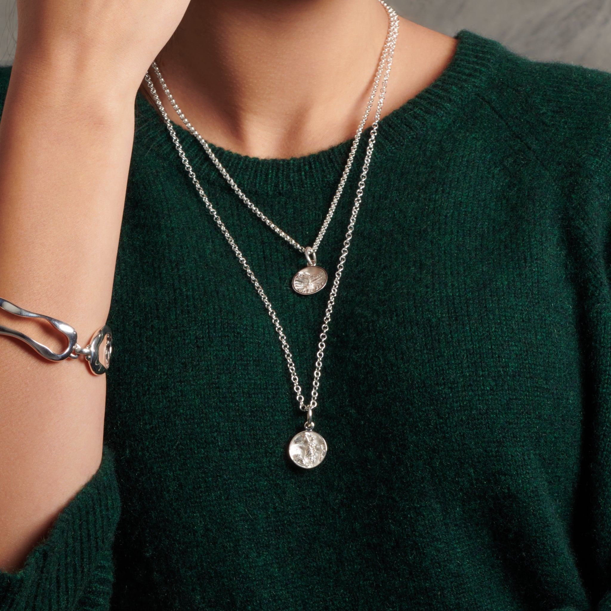 Model wearing a handcrafted sterling silver necklace pendant 'en relief' with culture from France.
