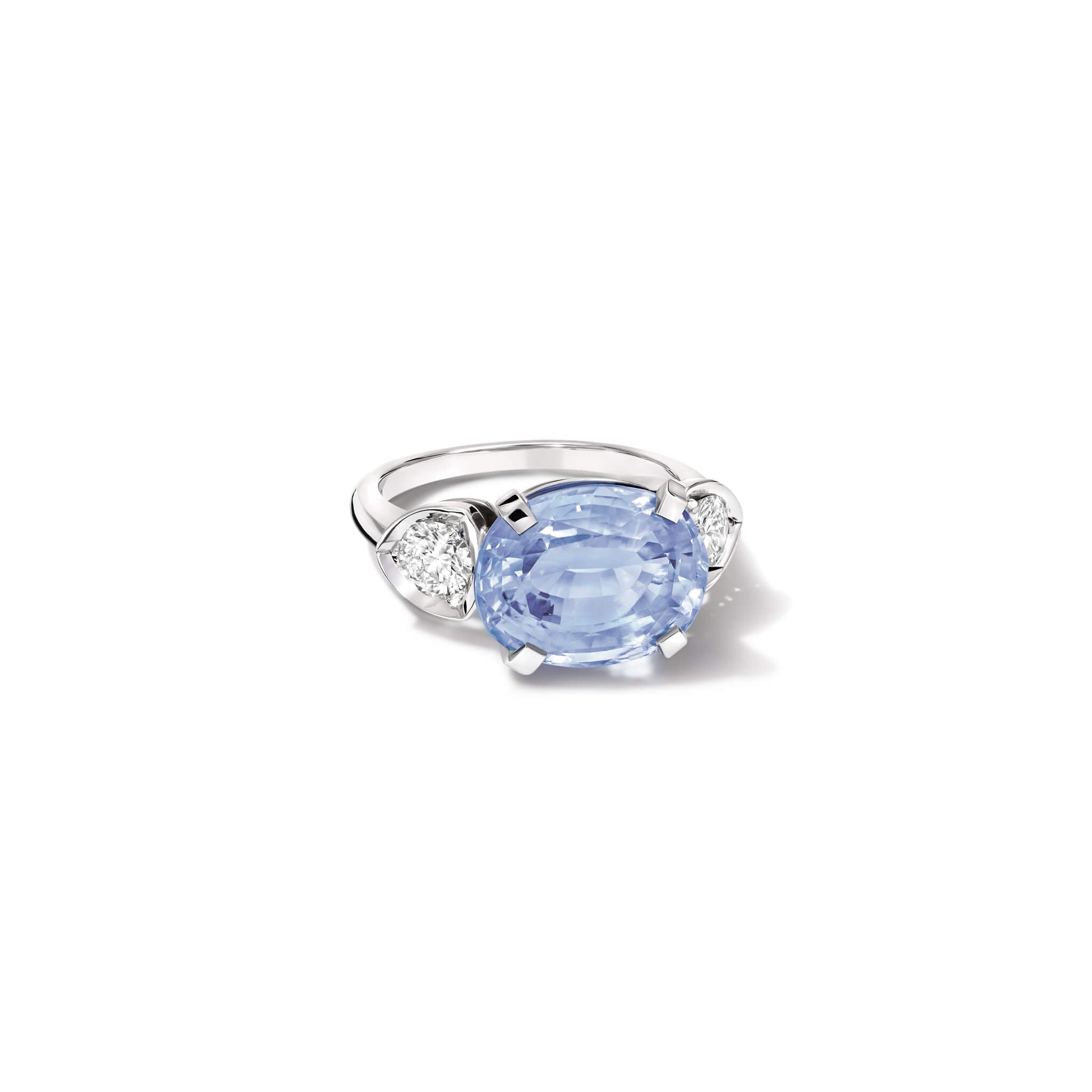 Handcrafted 18ct white gold engagement ring featuring a large central oval sapphire set horizontally, flanked by one smaller teardrop-shaped diamond on each side.