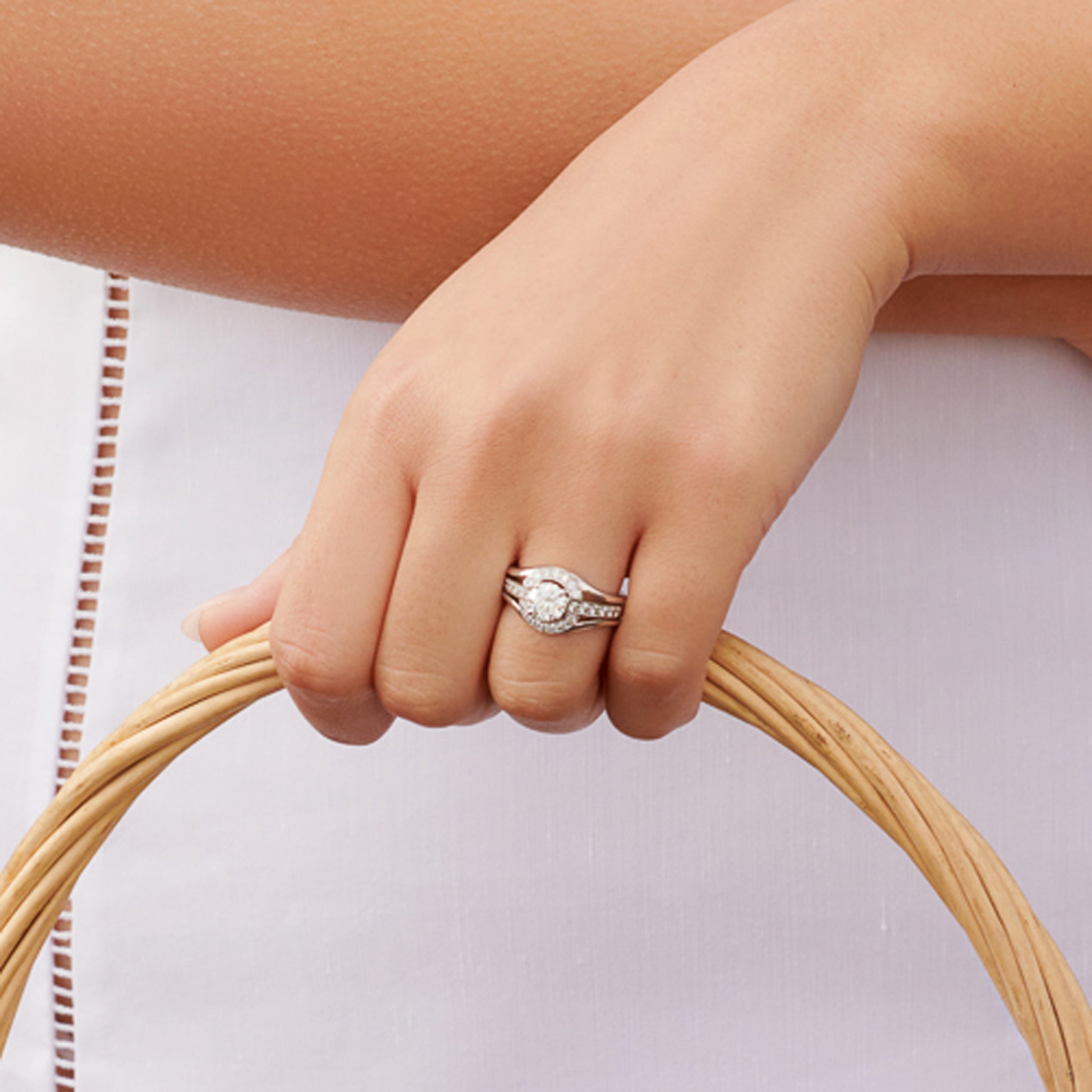Model wearing a handcrafted 18ct white gold ring featuring an open jacket setting with diamond pav�, designed to seamlessly accommodate another ring. Perfect as a wedding or eternity ring.
