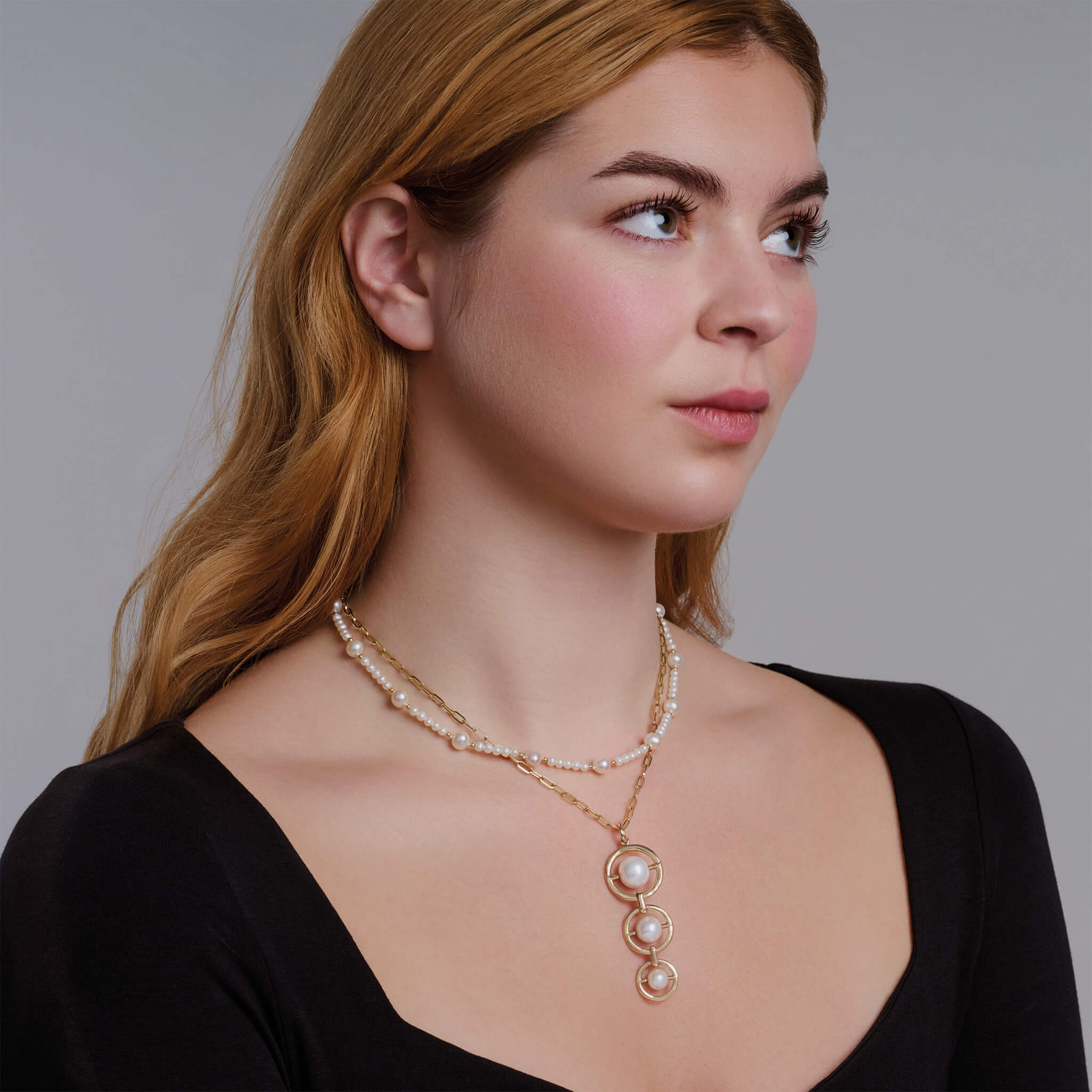 Model wearing a handcrafted yellow gold necklace with small pearls.