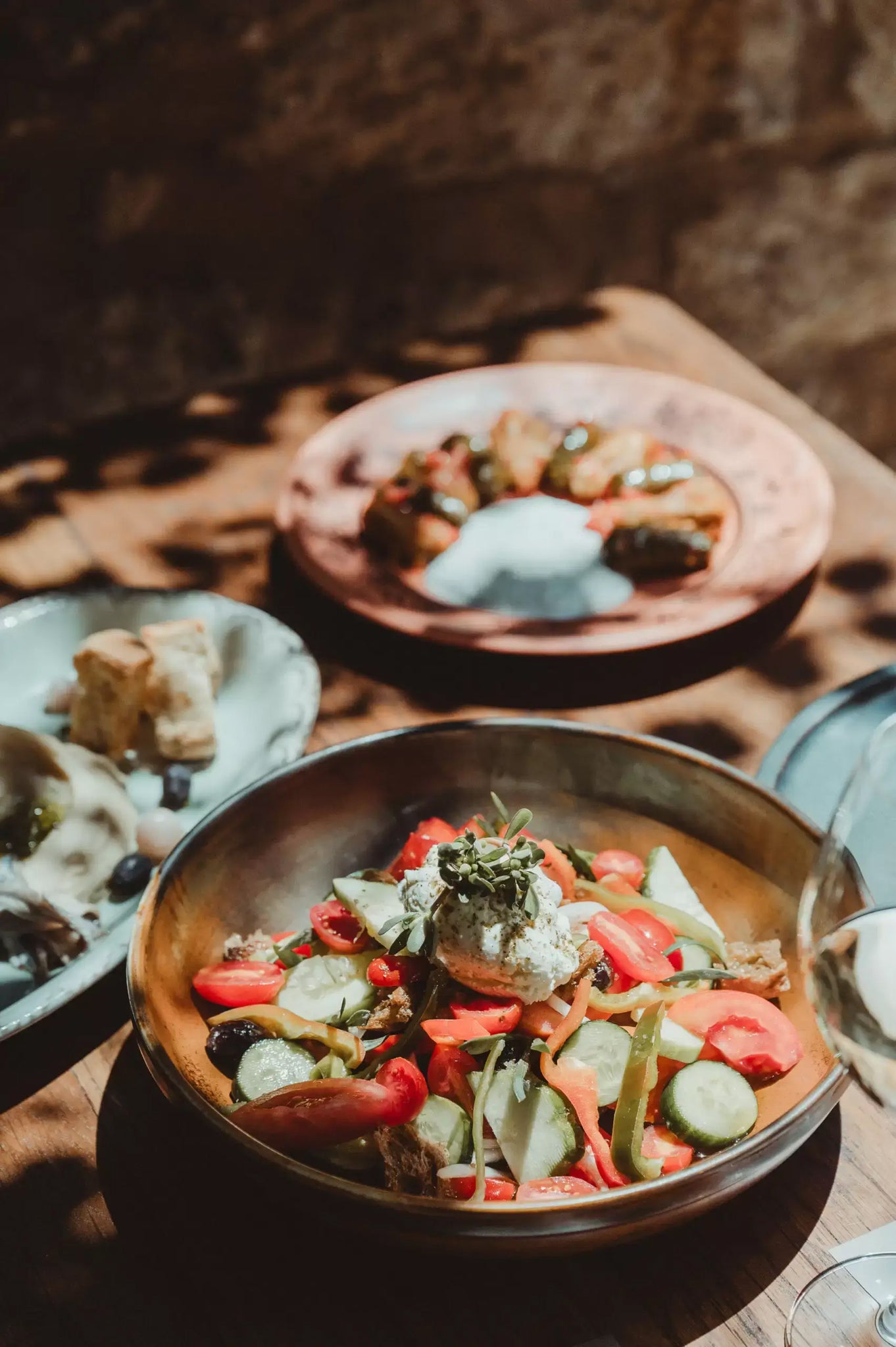 Table with lots of dishes of Cretan cuisine in Peskesi restaurant.