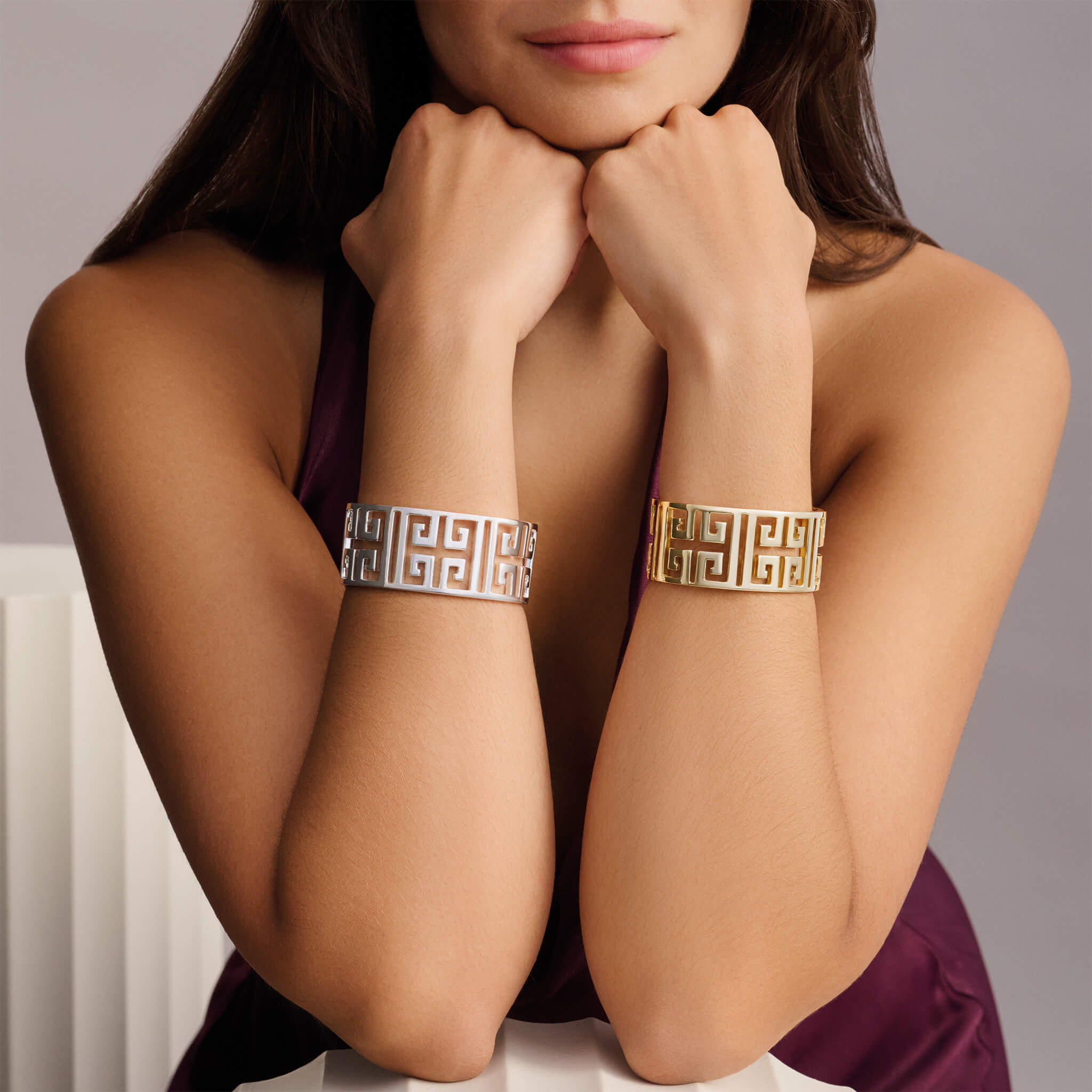 Model wearing handcrafted yellow gold and silver cuffs inspired by greece, meandros a symbol of eternity