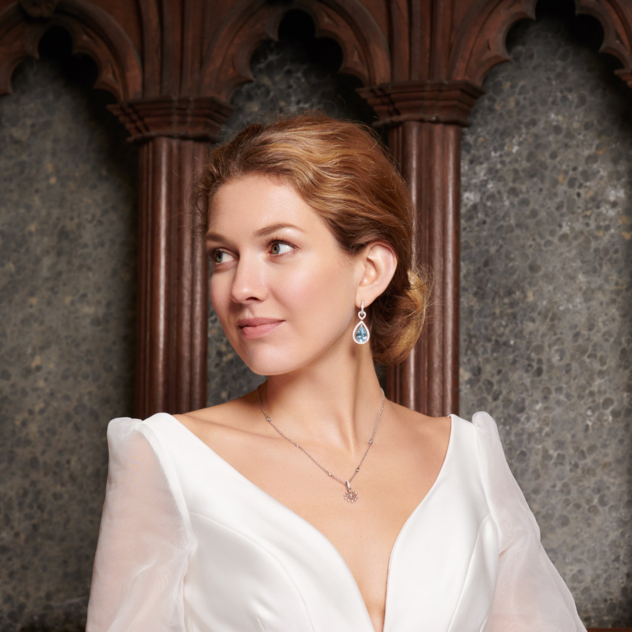 Model wearing a handcrafted 18ct white gold necklace pendant inspired by the delicate spurs of an astrantia flower, with diamonds set at the tip of each spur.