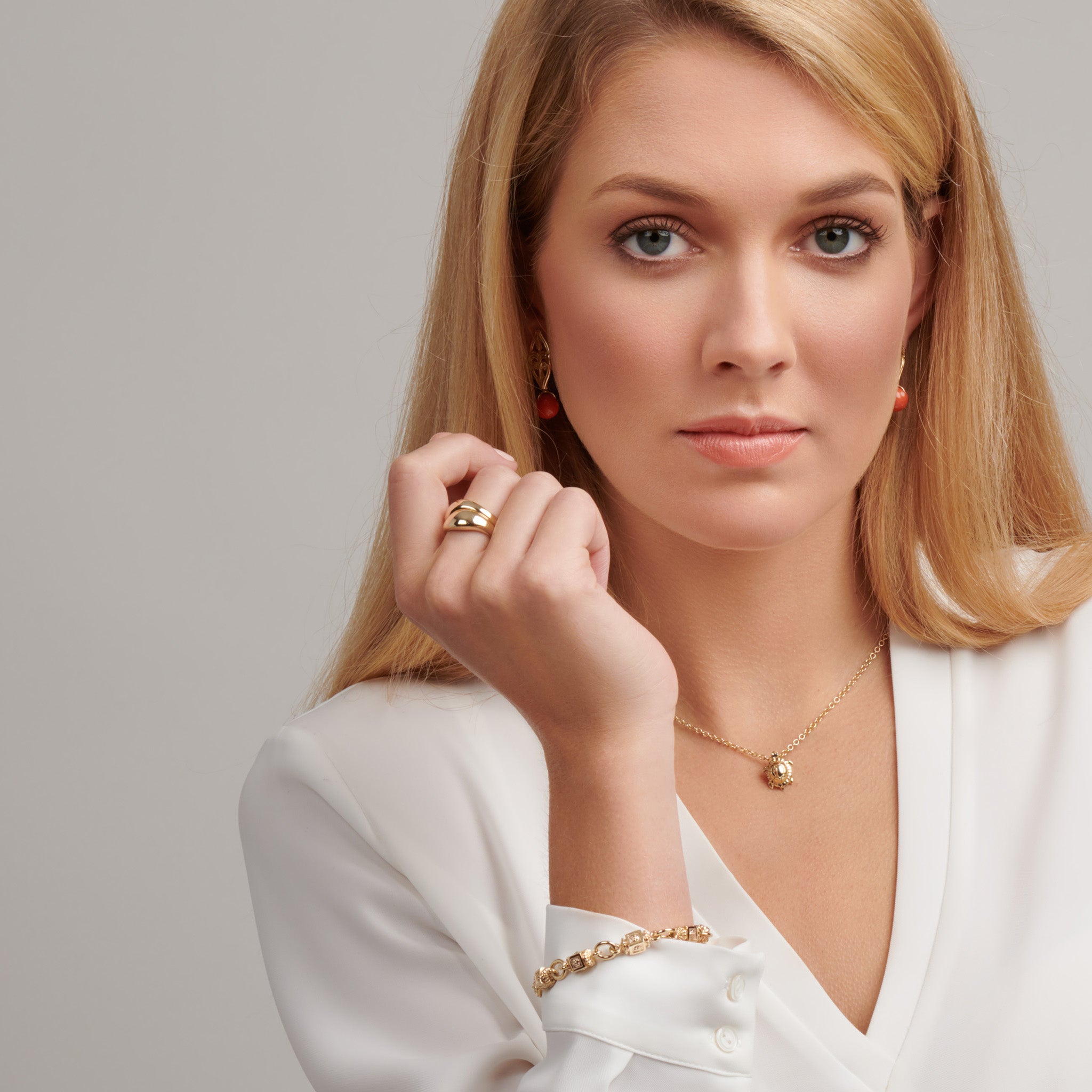 Model wearing a handcrafted yellow gold ring with a slight teardrop design at the top.