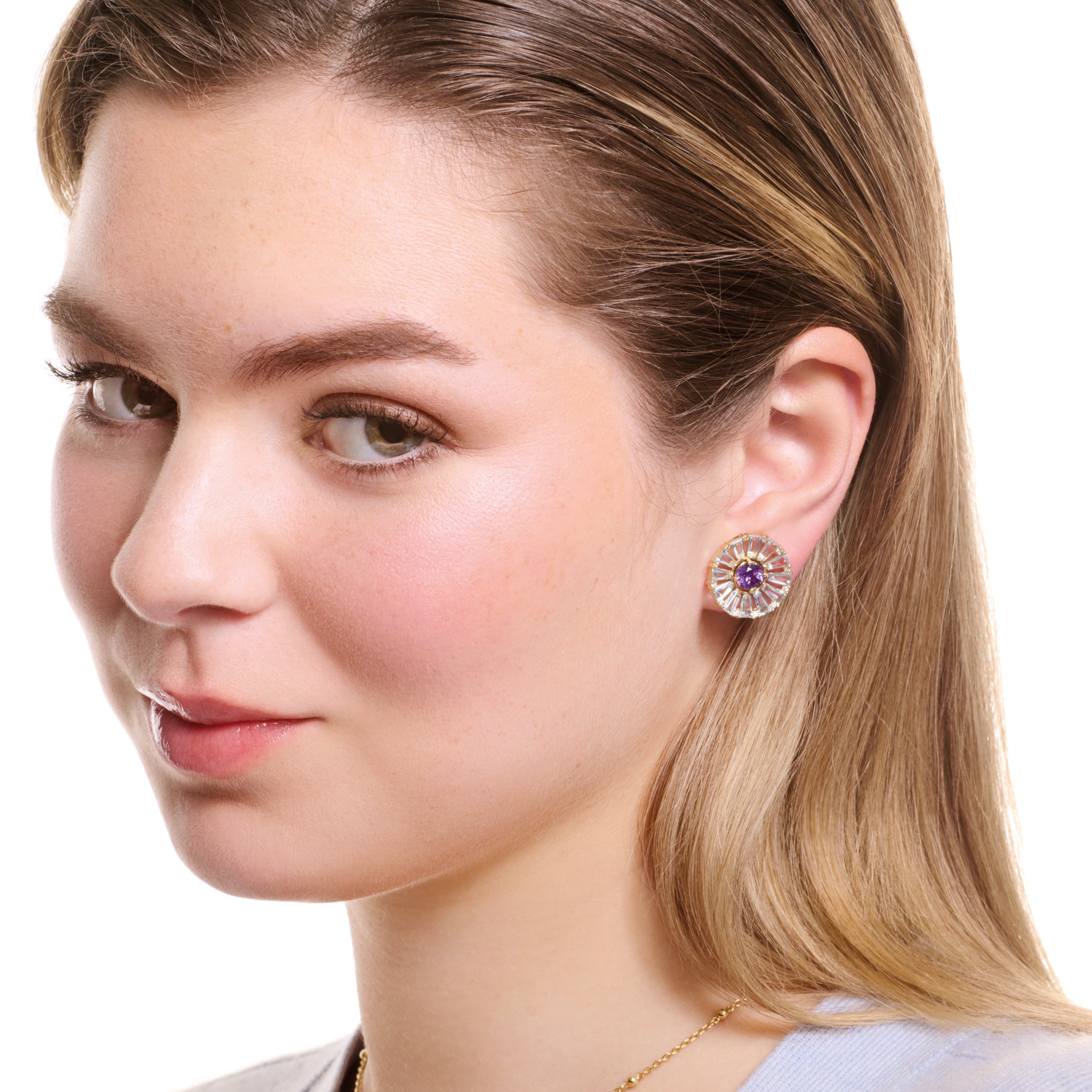 Model wearing handcrafted yellow gold earring halos with baguette cut precious gemstones.