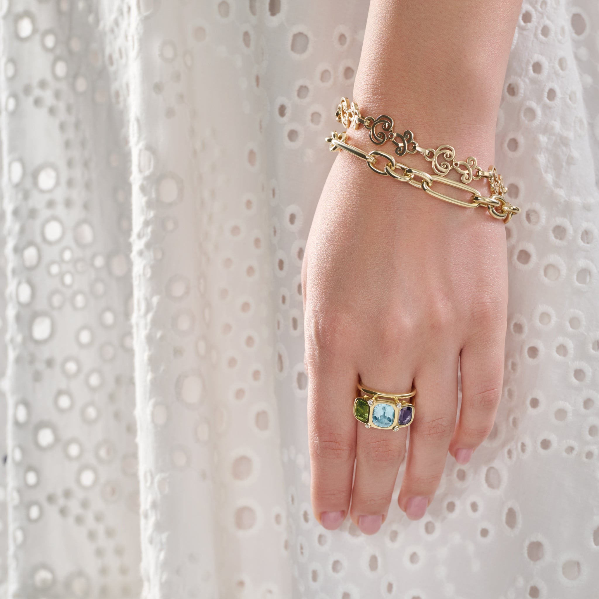 Model wearing a handcrafted 18ct white gold ring featuring rectangular shaped precious gemstones and diamonds.