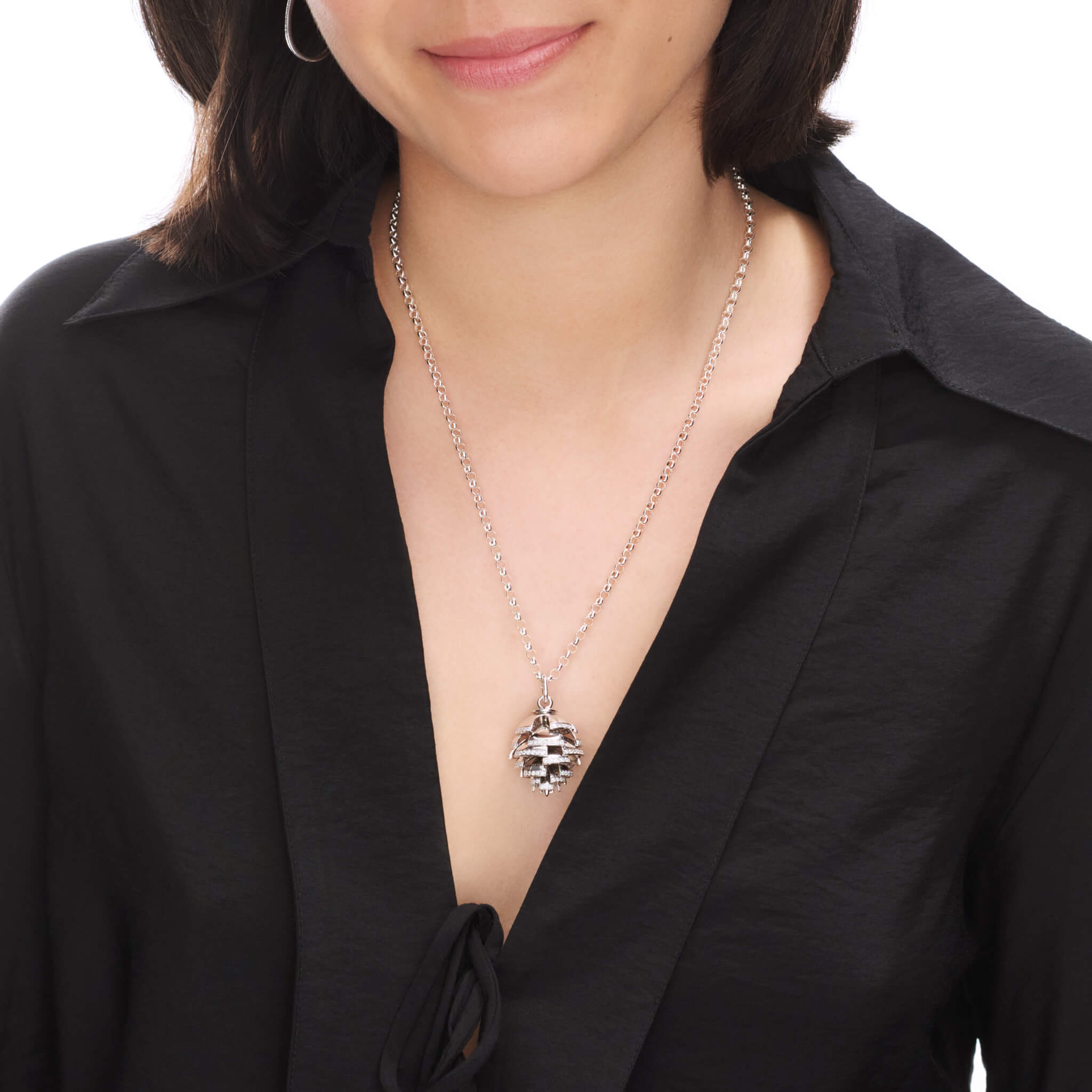 Model wearing a handcrafted white gold fir cone shaped necklace pendant with diamonds.