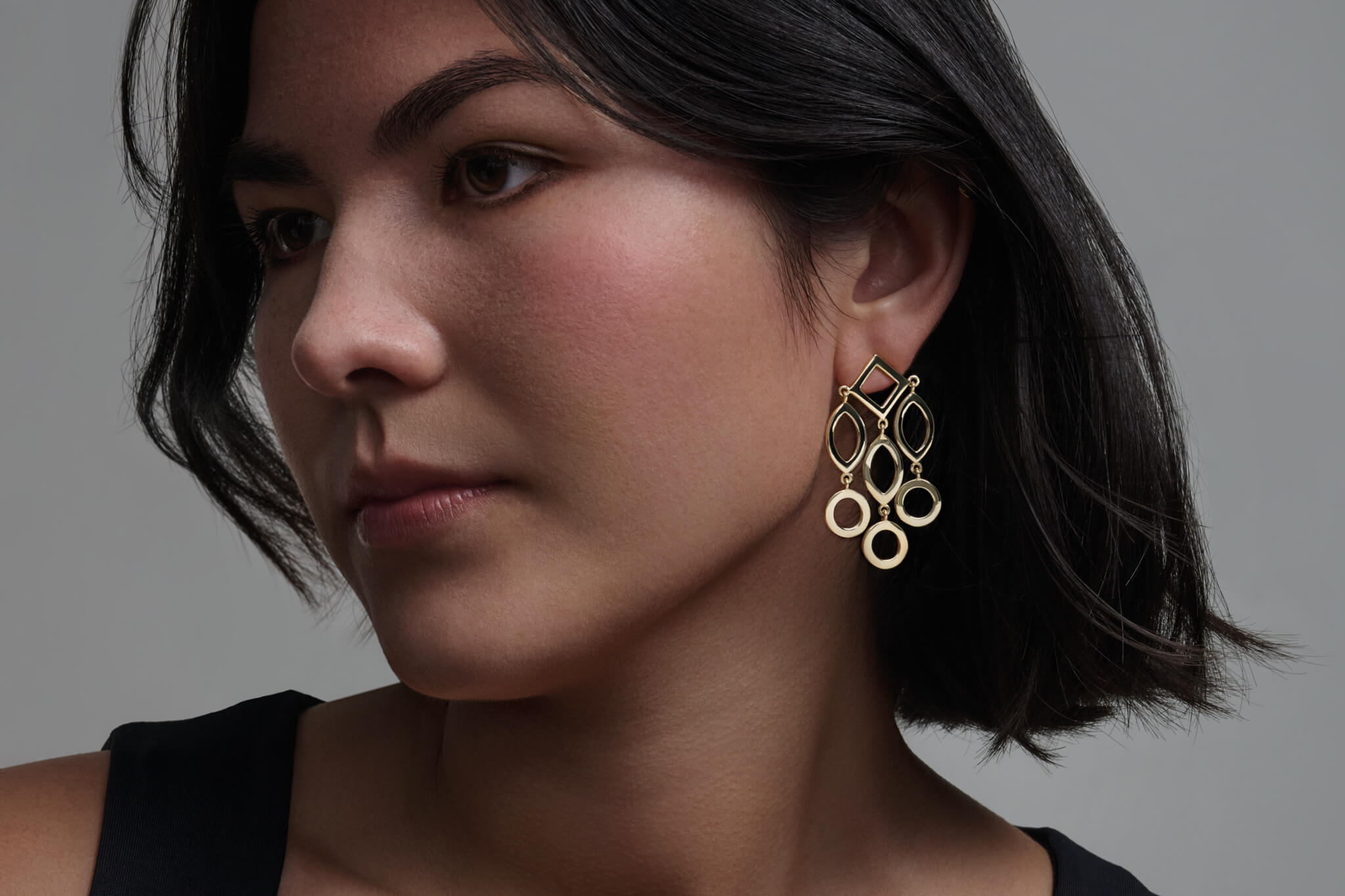 Model wears handcrafted Temple of Heaven earrings with a geometric design.