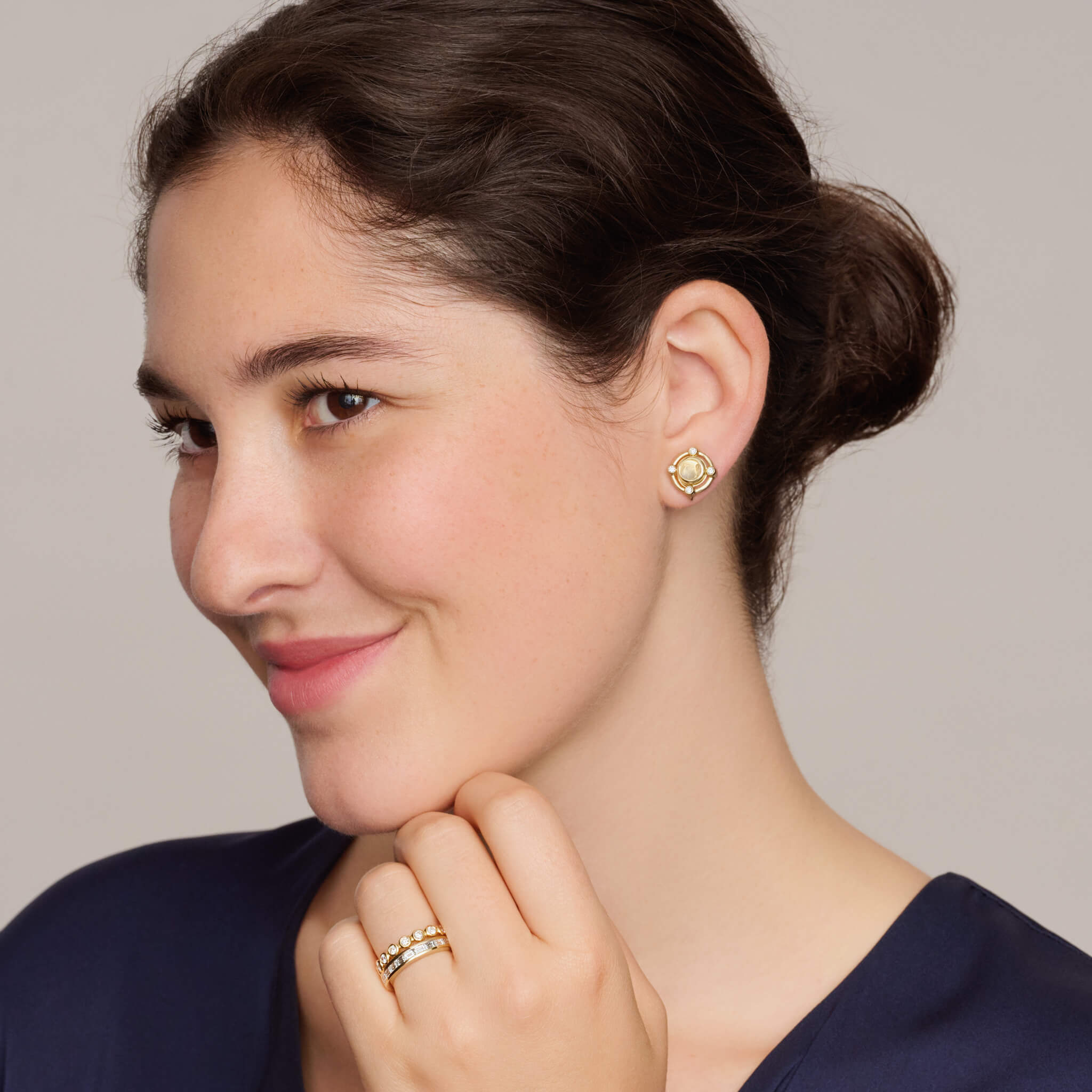 model wearing handcrafted interchangeable stud earrings in yellow gold with cabochon blue moonstone