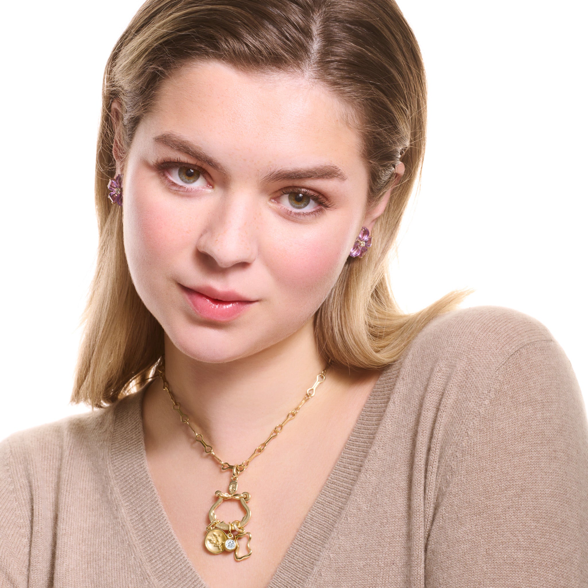 Model wearing a handcrafted yellow gold necklace pendant with three distinct charms elegantly suspended from it.